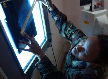 Air Force Staff Sgt. Erika Haskins uses a ruler to measure a mammogram film to pinpoint areas that are more likely to develop breast cancer at Aviano Air Base, Italy, Nov. 1, 2004.