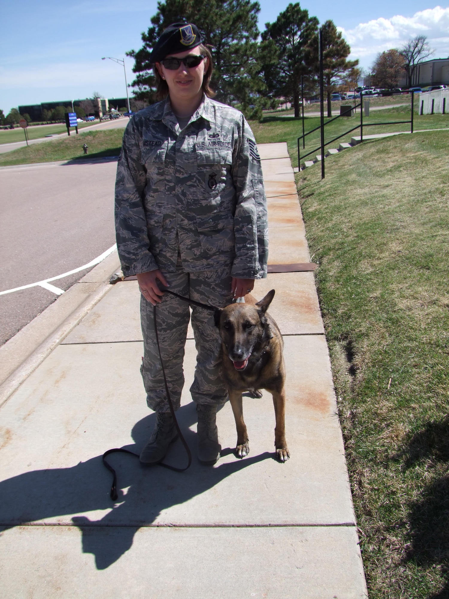 Tech. Sgt. Ashley-Marie Umstead stands with therapy dog Sato, a 5-year-old Belgian Malinois. Sato is a retired military working dog now serving as a therapy dog at the U.S. Air Force Academy, Colo. He previously served as a bomb dog for the 10th Security Forces Squadron.  (U.S. Air Force photo/Amber Baillie)  