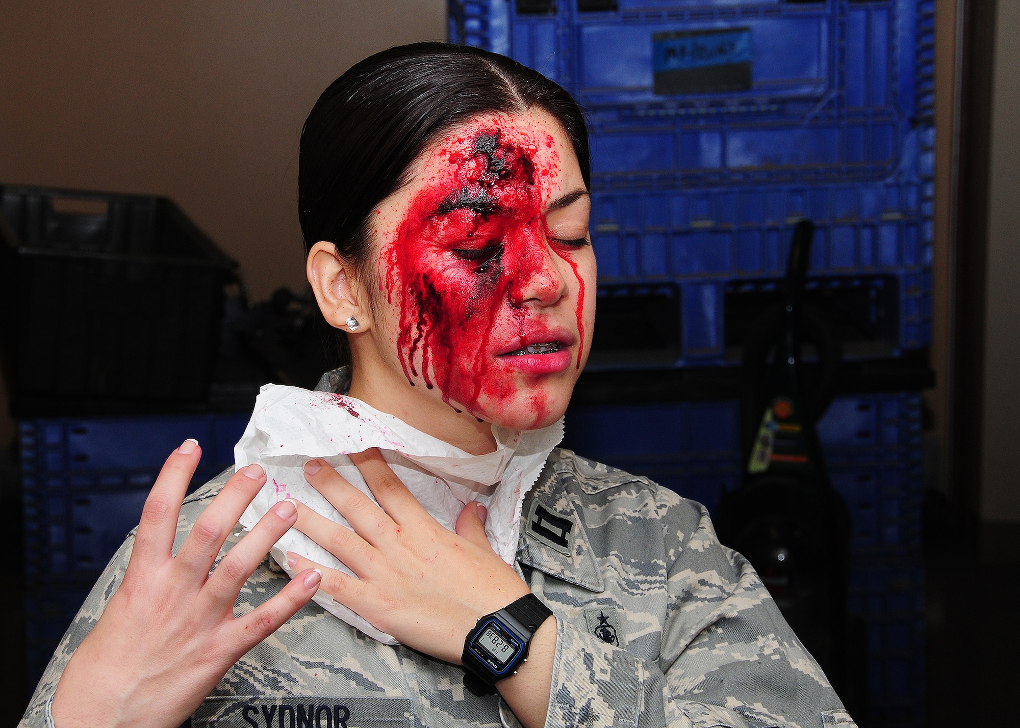 Senior Airman Bianca Lopez, 944th Medical Squadron medical administration specialist, isimulates a patient during the “Operations Patriot Bluebird,” joint exercise hosted by the 944th Aeromedical Squadron May 1. The use of moulage on patients ensures the training is more realistic when replicating injuries which helps prepare airmen for when they come across this type of scenario in the real world. It also provides a since of urgency for medical personnel.(U.S. Air Force photo/Texh Sgt. Louis Vega, Jr.)