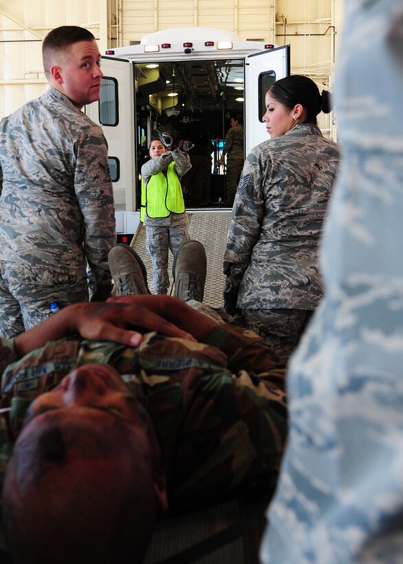 Staff Sgt. Renee Boehm, 944th Aeromedical Staging Squadron medical technician, directs joint exercise team members onto a Dual Use Vehicle during the “Operations Patriot Bluebird” joint exercise while members perform causality movement using NATO litters and gurneys at Luke Air Force Base, Ariz. The bus converts to a patient evacuation vehicle and provides transportation of passengers and patients including ambulatory, wheelchair and litter born during disasters or emergencies. (U.S. Air Force photo taken by Tech. Sgt. Louis Vega Jr.)
