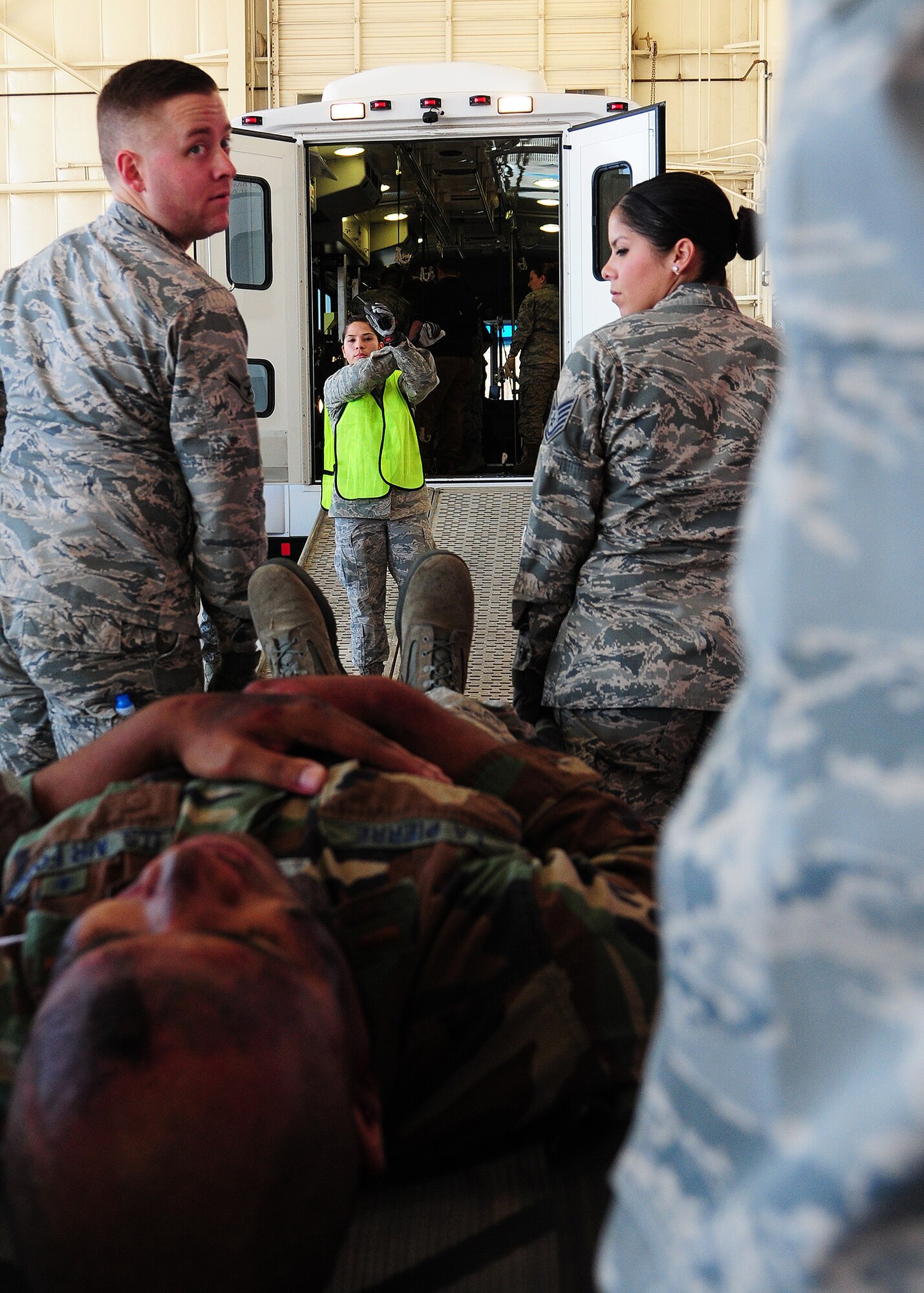 Staff Sgt. Renee Boehm, 944th Aeromedical Staging Squadron medical technician, directs joint exercise team members onto a Dual Use Vehicle during the “Operations Patriot Bluebird” joint exercise while members perform causality movement using NATO litters and gurneys at Luke Air Force Base, Ariz. The bus converts to a patient evacuation vehicle and provides transportation of passengers and patients including ambulatory, wheelchair and litter born during disasters or emergencies. (U.S. Air Force photo taken by Tech. Sgt. Louis Vega Jr.)
