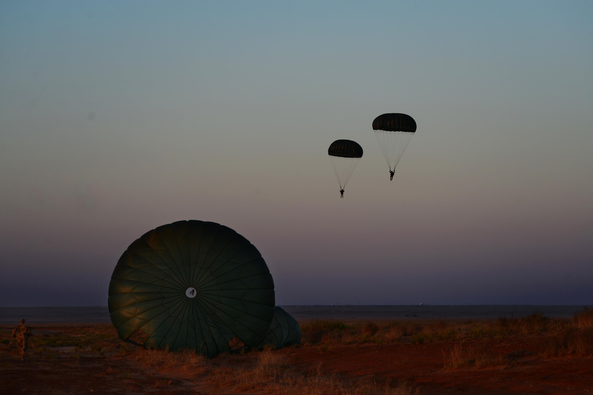 U.S. Army Soldiers from the 193rd Infantry Brigade and U.S. Air Force Airmen from the 26th Special Tactics Squadron land after a parachute jump as a part of Emerald Warrior April 28, 2015 at Melrose Air Force Range, N.M. Emerald Warrior is the Department of Defense’s only irregular warfare exercise, allowing joint and combined partners to train together and prepare for real world contingency operations. (U.S. Air Force Photo/Airman 1st Class Shelby Kay-Fantozzi)