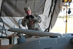Spc. Blake Daniels attaches streamers to one of the RQ-7's antennas during a post flight inspection. He is an RQ-7 "Shadow" maintainer with the 45th Special Troops Battalion, 45th Infantry Brigade Combat Team of the Oklahoma Army National Guard.