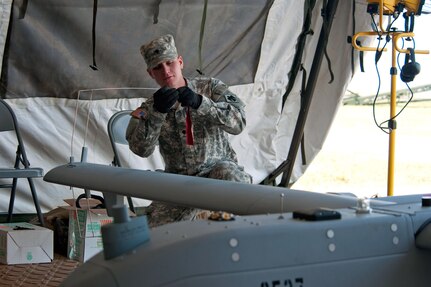 Spc. Blake Daniels attaches streamers to one of the RQ-7's antennas during a post flight inspection. He is an RQ-7 "Shadow" maintainer with the 45th Special Troops Battalion, 45th Infantry Brigade Combat Team of the Oklahoma Army National Guard.