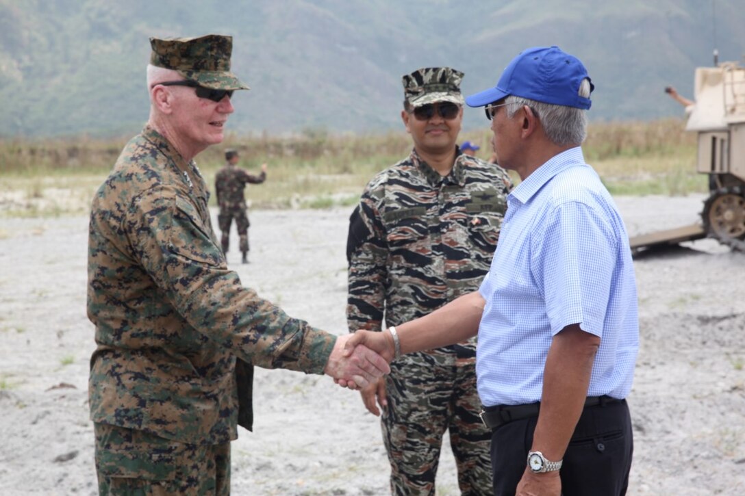 U.S. Marine Corps Forces Pacific Commander, Lt. Gen. John A. Toolan, shakes hands with Secretary Voltaire Gazmin, the Philippine Secretary of Defense, after viewing a static display of mechanized military vehicles at the conclusion of the Combined Arms Live-Fire Exercise (CALFEX) during Balikatan 2015 at Crow Valley, Tarlac, Philippines, April 30. The CALFEX is the culminating event for Balikatan which demonstrates the relationship and teamwork between the United States and the Philippine military.