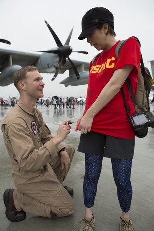 A Marine with Marine Aerial Refueler Transport Squadron 152 signs a Japanese visitors shirt during the Japan Maritime Self-Defense Force/Marine Corps Air Station Iwakuni Friendship Day 2015 Air Show aboard MCAS Iwakuni,Japan, May 3, 2015. This year the event expanded to combine both the Fleet Air Wing 31 annual Open House and the traditional MCAS Iwakuni Friendship Day, resulting in the first-ever joint Friendship Day air show. The event allowed visitors a chance to see the military installation and interact with Japanese and American service members while enjoying performances from the Breitling Wingwalkers, Blue Impulse and much more. (U.S. Marine Corps photo by Cpl. Luis Ramirez)