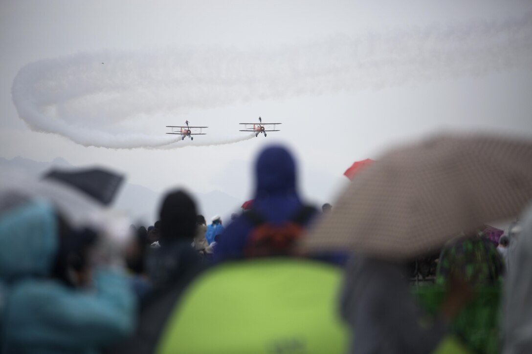 Visitors watch as the Breitling Wingwalkers perform during the Japan Maritime Self-Defense Force/Marine Corps Air Station Iwakuni Friendship Day 2015 Air Show aboard MCAS Iwakuni, Japan, May 3, 2015. This year the event expanded to combine both the Fleet Air Wing 31 annual Open House and the traditional MCAS Iwakuni Friendship Day, resulting in the first ever joint Friendship Day air show. The event allowed visitors a chance to see the military installation and interact with Japanese and American service members while enjoying performances from the Breitling Wingwalkers, Blue Impulse and much more.