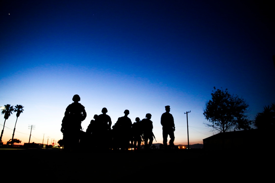 Recruits and drill instructors of Golf Company, 2nd Recruit Training Battalion, hike along Edson Range, Marine Corps Base Camp Pendleton, Calif., April 28. The company started the hike at dusk and night quickly fell over them. During this training exercise, the recruits must resupply under the cover of darkness. The ammunition can resupply is designed to teach the recruits how to be tactical at night while practicing light and noise discipline. Today, all male recruits recruited from recruiting stations west of the Mississippi are trained at MCRD San Diego. The depot is responsible for training approximately 16,000 recruits annually. Golf Company is scheduled to graduate May 8.