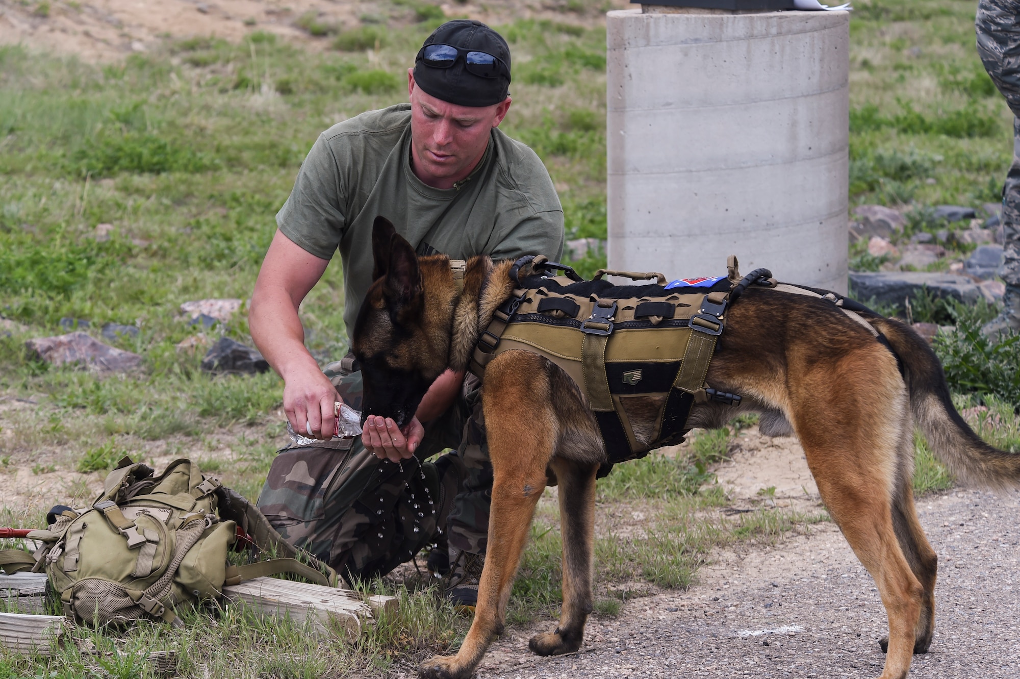 A military working dog handler provides his MWD with water during a break in the Cpl. David Sonka Memorial Competition May 3, 2015, at the 460th Security Forces training field on Buckley Air Force Base, Colo. The weekend’s events were held to honor the life of Sonka, a U.S. Marine Corps Military Working Dog handler who was killed in action in Afghanistan May 4, 2013. The weekend’s events included a motorcade to his grave, two memorial services, the reading of the names of all MWD and MWD handlers killed in action during Vietnam and recent years, a BBQ, and concluded with a multi-service dog handling competition. (U.S. Air Force photo by Senior Airman Phillip Houk/Released)