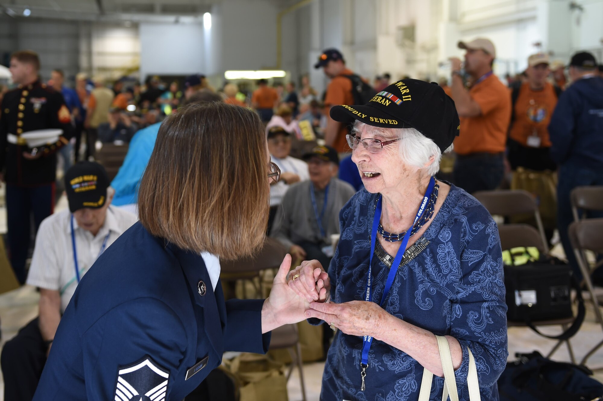 Master Sgt. Peggee Larkin, 566 Intelligence Squadron first sergeant, talks with a female World War II veteran before she boards a plane May 3, 2015, at Denver International Airport in Denver. The veteran, along with 75 other World War II, Vietnam, Korea, terminally ill and Purple Heart recipient veterans, took a trip to Washington D.C. to visit military memorials. The overnight trip was hosted by the Honor Flight of Northern Colorado and is offered every year free of charge for the vets through donations from the public. (U.S. Air Force photo Airman 1st Class Samantha Meadors/Released)