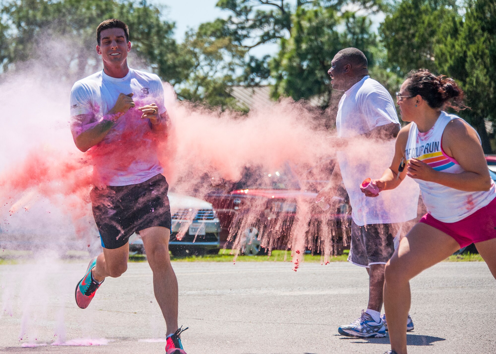 Volunteers shower a participant with powdered color at the last color station of the Color Me Aware Fun Run, April 30, at Eglin Air Force Base, Fla.  Approximately 20 volunteers tossed powdered colors on more than 400 runners and walkers during the three-mile course.  The event closed out Sexual Assault Awareness Month activities. (U.S. Air Force photo/Ilka Cole)