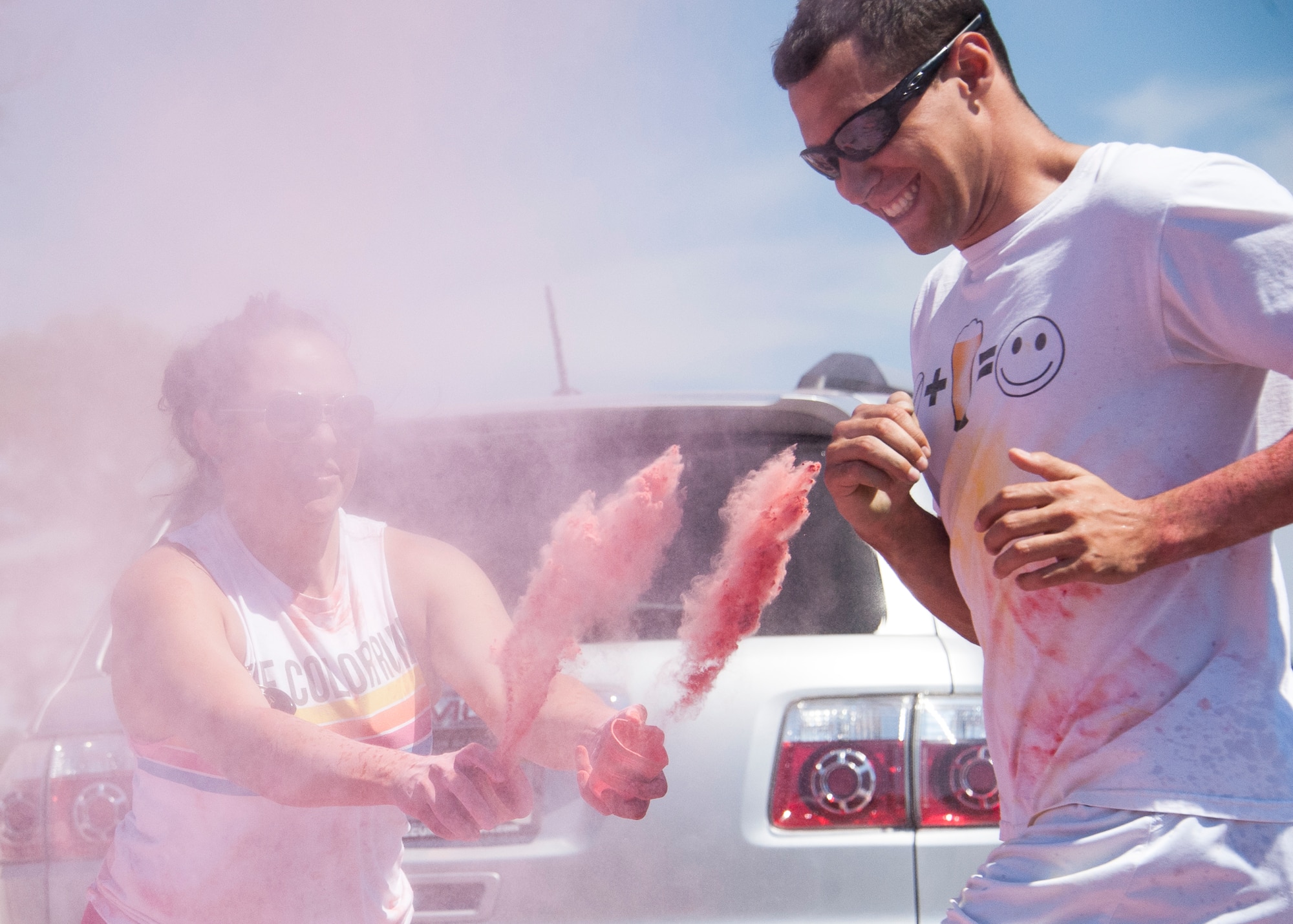 A volunteer throws powdered color at a participant at the last color station of the Color Me Aware Fun Run, April 30, at Eglin Air Force Base, Fla.  Approximately 20 volunteers tossed powdered colors on more than 400 runners and walkers during the three-mile course.  The event closed out Sexual Assault Awareness Month activities. (U.S. Air Force photo/Ilka Cole)