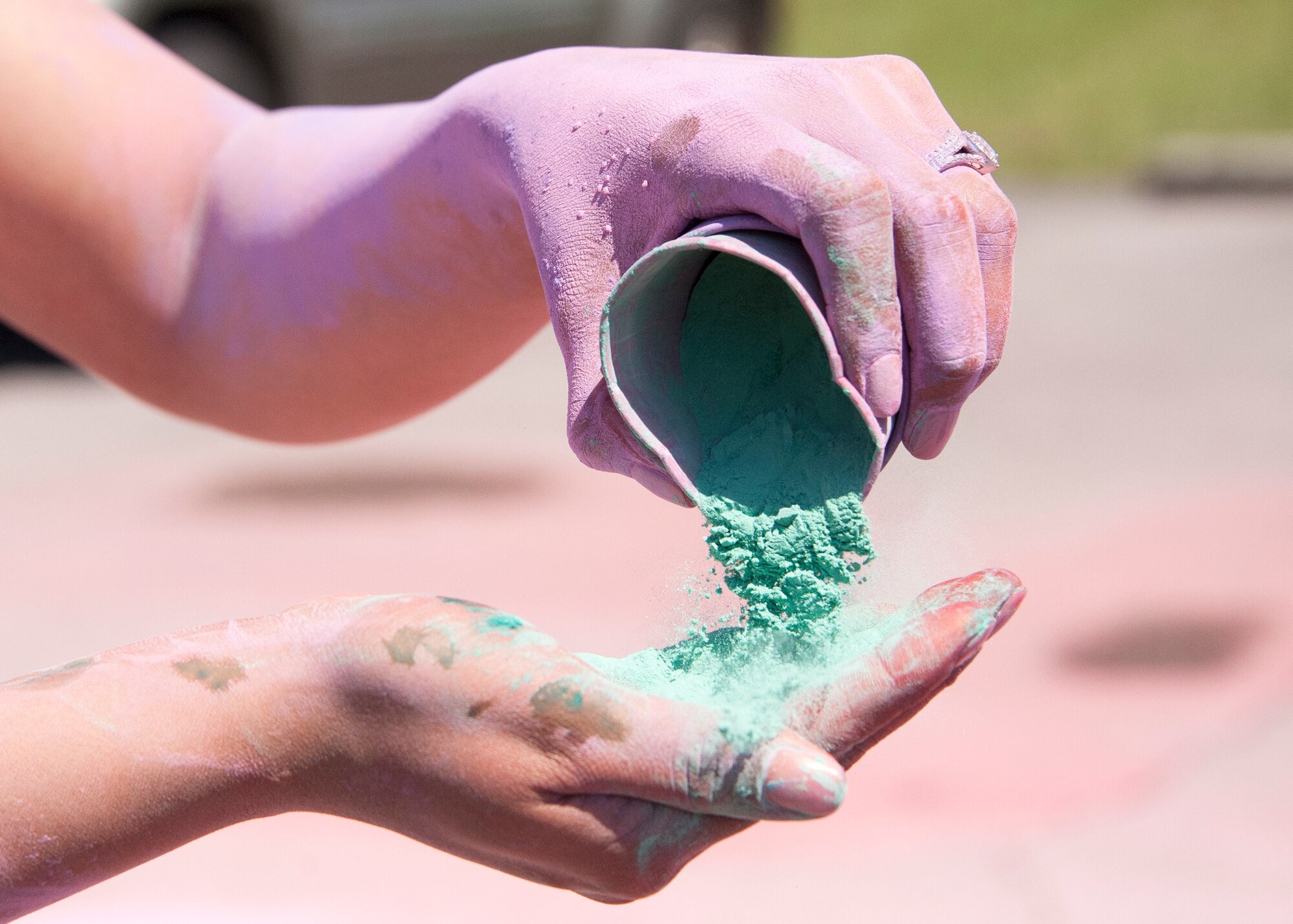 A volunteer pours powder into her hand at the Color Me Aware Fun Run, April 30, at Eglin Air Force Base, Fla. Approximately 20 volunteers from the 96th Force Support Squadron and volunteer victim advocates tossed powdered colors on more than 400 runners and walkers during the three-mile course.  The event closed out Sexual Assault Awareness Month activities. (U.S. Air Force photo/Ilka Cole)