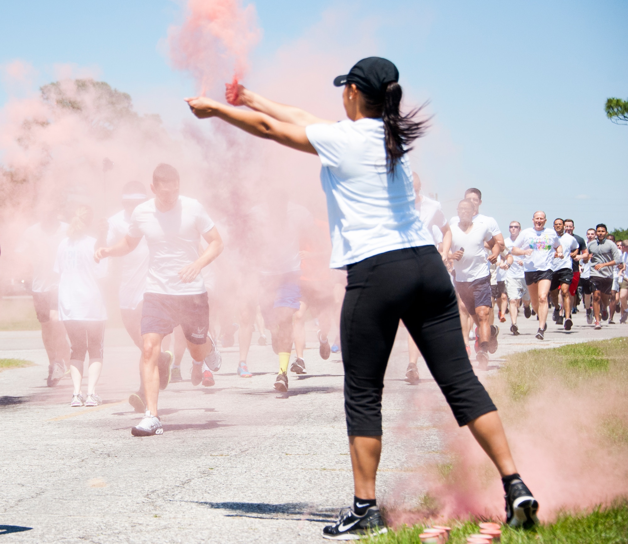 A volunteer throws powdered color at participants during the Color Me Aware Fun Run, April 30, at Eglin Air Force Base, Fla.  Approximately 20 volunteers tossed powdered colors on more than 400 runners and walkers during the three-mile course.  The event closed out Sexual Assault Awareness Month activities. (U.S. Air Force photo/Ilka Cole)
