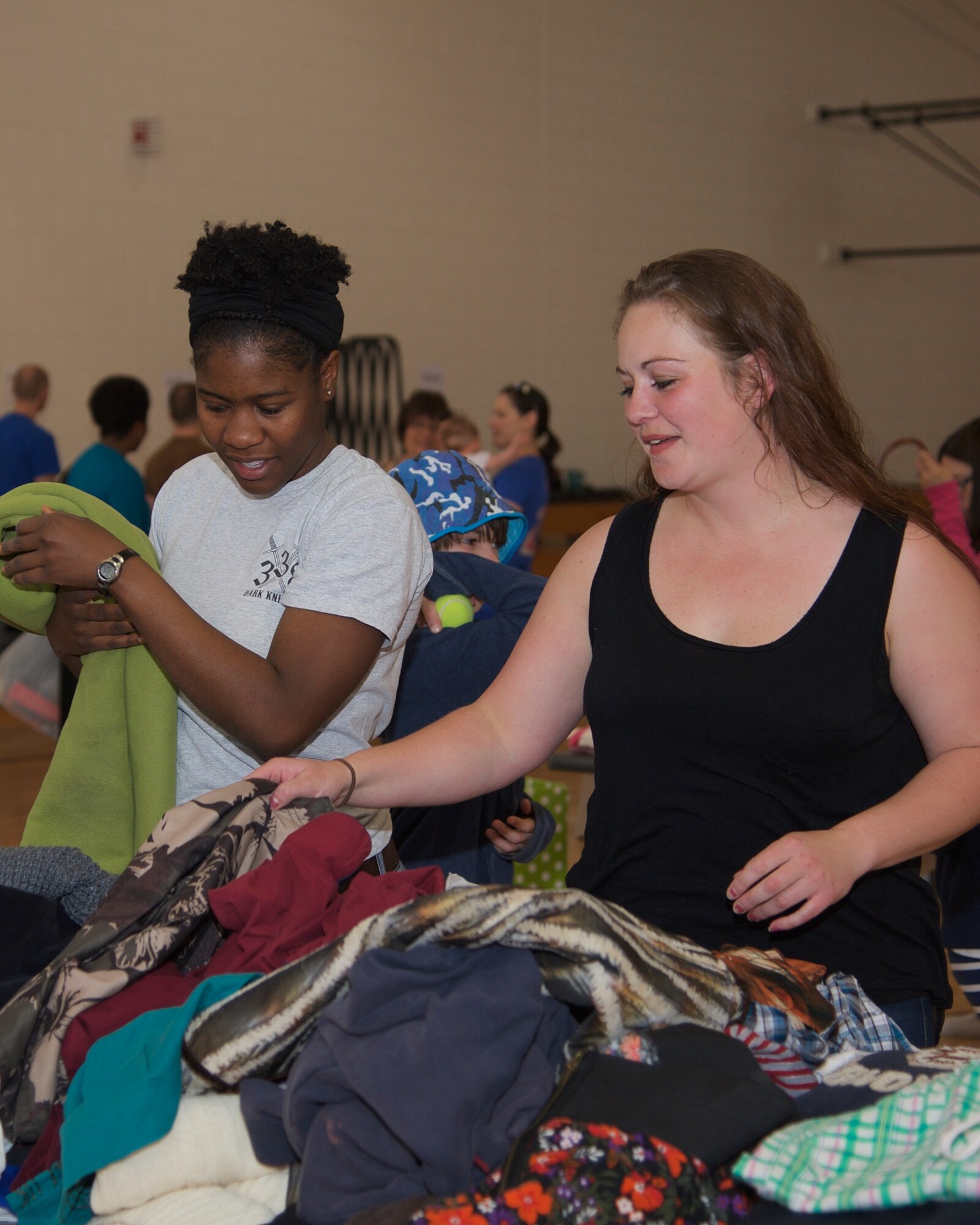 PETERSON AIR FORCE BASE, Colo. -- Volunteers Asia McClain and Karla McCormick sort and organize clothes during this year’s clothing drive at the R.P Lee Youth Center on Peterson AFB May 2. The Peterson Schriever Cheyenne Mountain Spouses’ Club and a team of volunteers spent the month of April collecting and sorting gently used children’s clothes and other donations for the event, which were then distributed free to those attending the event. (U.S. Air Force photo by Staff Sgt. J. Aaron Breeden)