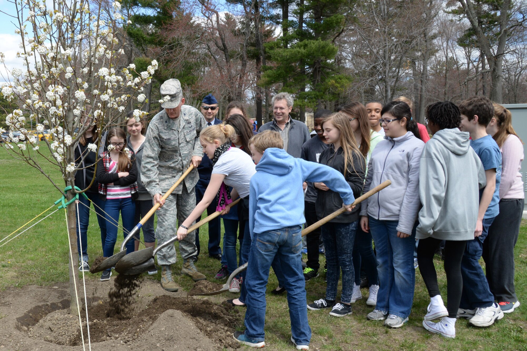 Col. Michael A. Vogel, 66th Air Base Group commander, and Hanscom Middle School students help plant a pear tree along Eglin Street near the clinic as part of Arbor Day activities April 29. The tree planting ceremony was just one of several efforts base personnel accomplished to achieve Tree City USA status for the 28th year in a row. (U.S. Air Force photo by Linda LaBonte Britt)