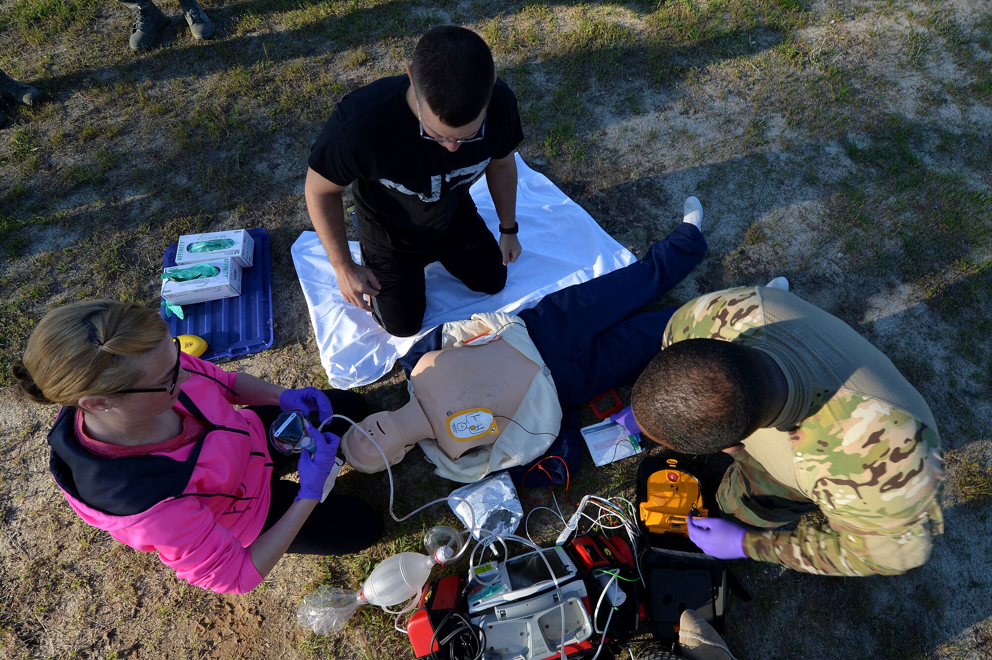 U.S. Air Force Airmen assigned to the 20th Medical Group work together to perform CPR on a practice dummy during an emergency management technician rodeo at Shaw Air Force Base, S.C., May 1, 2015. Nine teams of three participated in various physical and mental activities to complete them as efficiently and quickly as possible. (U.S. Air Force photo by Airman 1st Class Michael Cossaboom/Released)