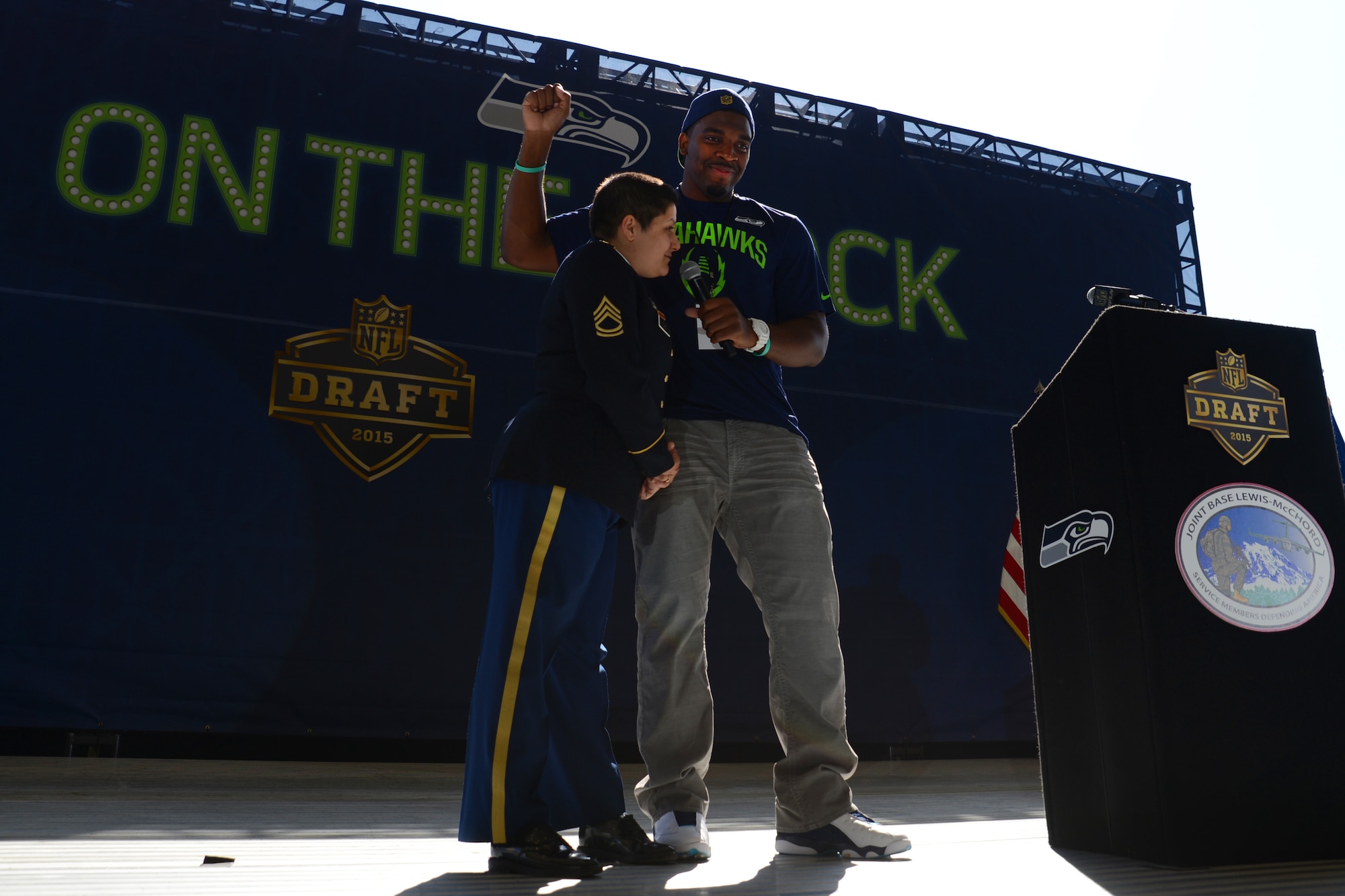 Sgt. 1st Class Madeline Diaz, 47th Combat Support Hospital, answers questions from Greg Scruggs, Seattle Seahawks defensive end, on Joint Base Lewis-McChord, Wash., May 2, 2015. Diaz announced one of the 2015 National Football League draft picks for the Seahawks during the JBLM draft day event. (U.S. Air Force photo\ Staff Sgt. Tim Chacon)