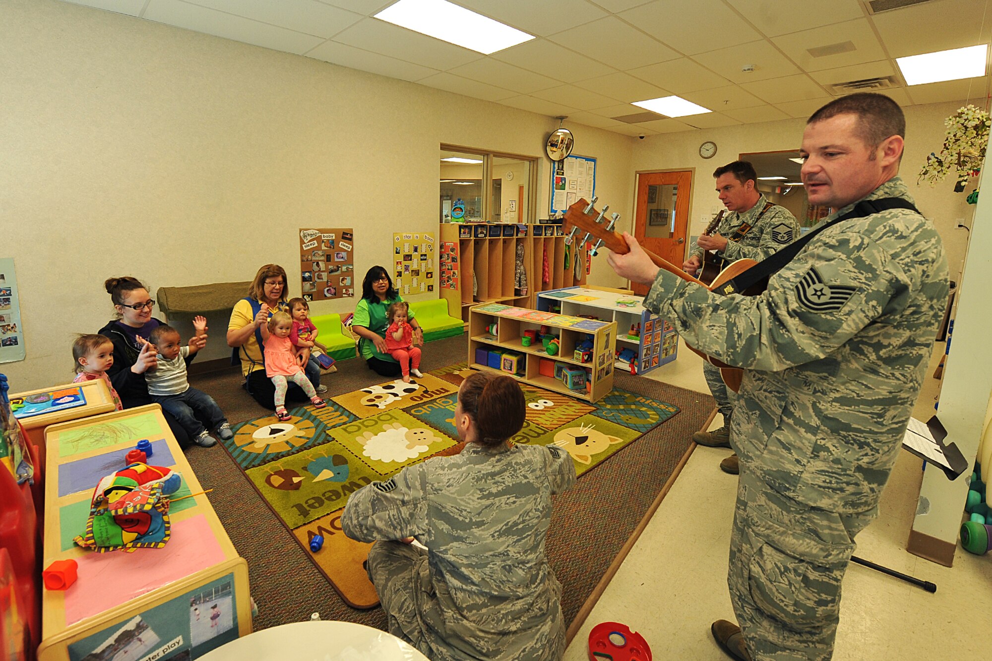 In recognition of the military child, the U.S. Air Force Heartland of America Band sings “The wheels on the bus” for various age groups at the child development center on Offutt AFB, Neb., April 27. The band is made up of various component ensembles which perform more than 150 concerts annually, performing extensively throughout Nebraska. (U.S. Air Force photo by Charles Haymond/Released) 