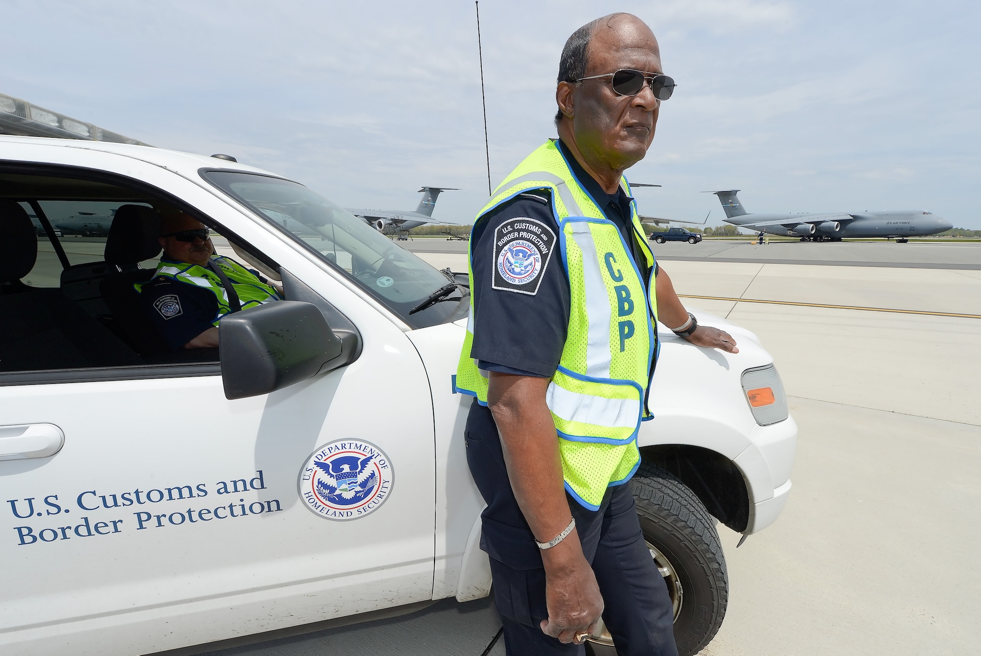Leroy Jubilee, U.S. Customs and Border Protection agricultural specialist, waits to perform his final agricultural inspection of an aircraft which has landed from overseas during his last day of work for Customs and Border Protection April 30, 2015, at Dover Air Force Base, Del. The aircraft he will soon inspect is a C-5M Super Galaxy of the 436th Airlift Wing which can be seen turning in to park in the background. Jubilee has 50 years of government service at his retirement date and is a senior agricultural expert for CBP on the East Coast. (U.S. Air Force photo/Greg L. Davis)