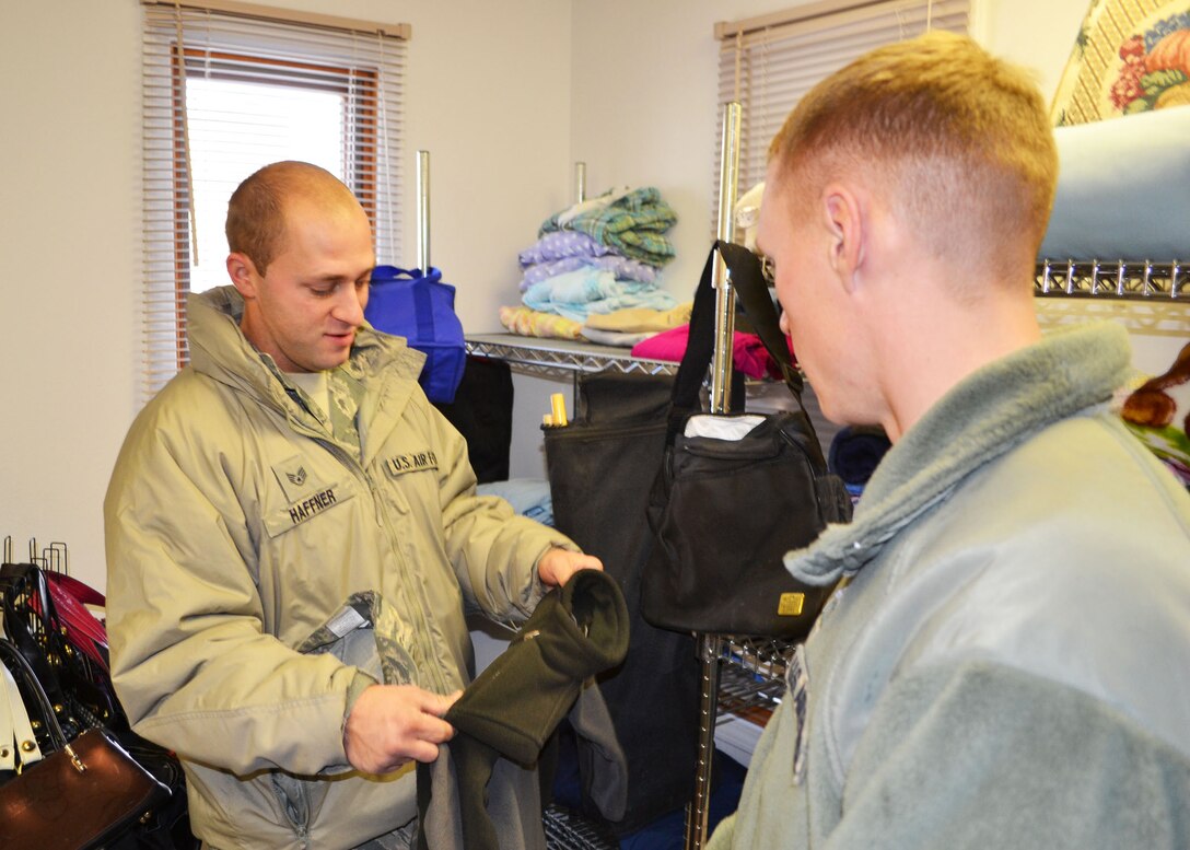Aerospace Ground Equipment Mechanic Staff Sgt. Dustin Haffner shops for a coat that his son may be able to use at the new 120th Airlift Wing Airman’s Attic on Dec. 6, 2014. The program provides an opportunity for members of the Montana Air National Guard to repurpose clean and serviceable clothing and household items. Air National Guard photo by Senior Master Sgt. Eric Peterson.