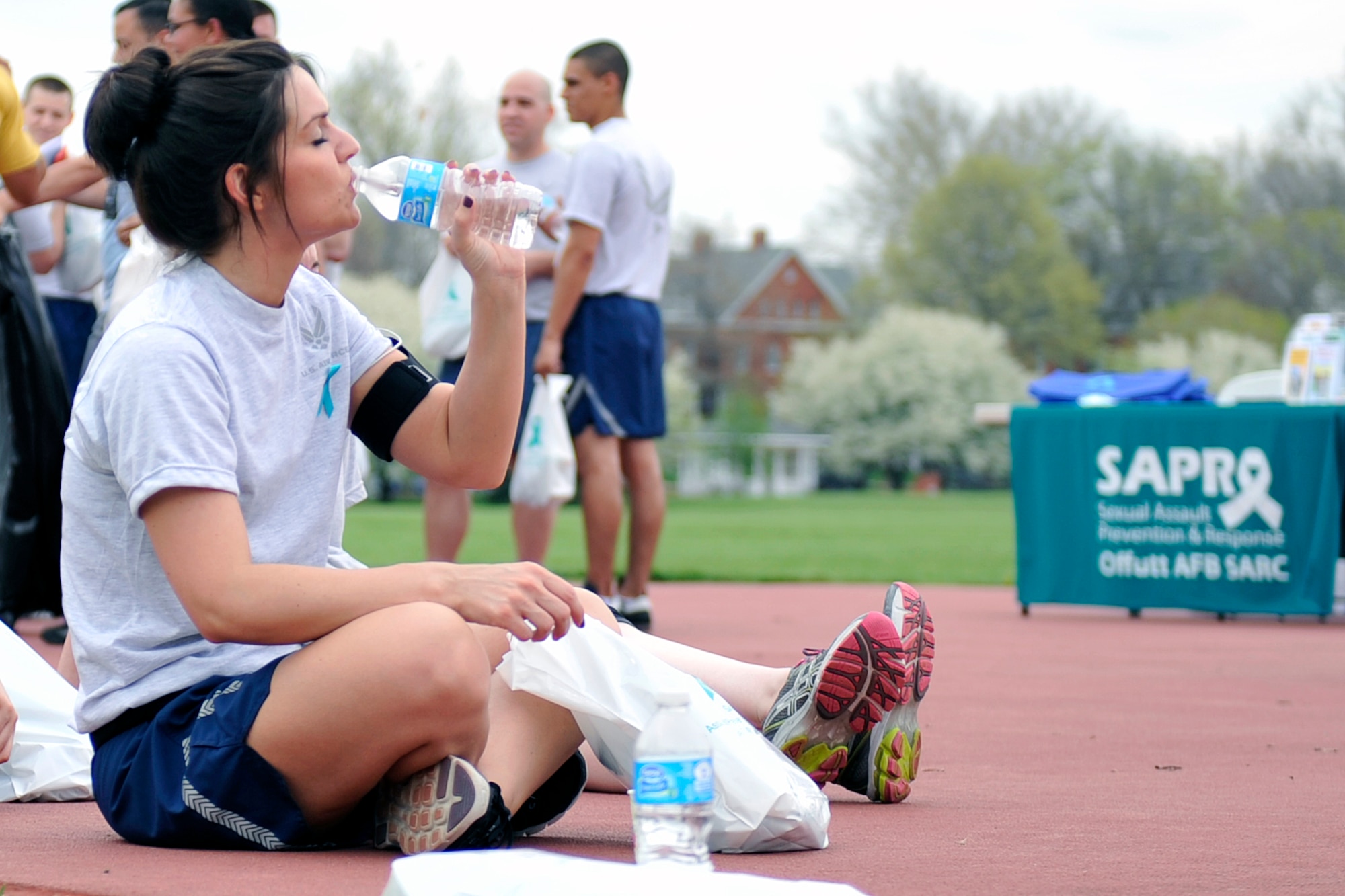 U.S. Air Force Staff Sgt. Laura Mickus, 2nd Weather Squadron, hydrates after her portion of the Sexual Assault Awareness and Prevention Month 5k relay race on the parade grounds April 17, Offutt Air Force Base, Neb. Units from across Team Offutt participated in the event including the 55th Wing, 557th Weather Wing and Naval Operational Support Center to name a few. (U.S. Air Force photo by Jeff W. Gates/Released)