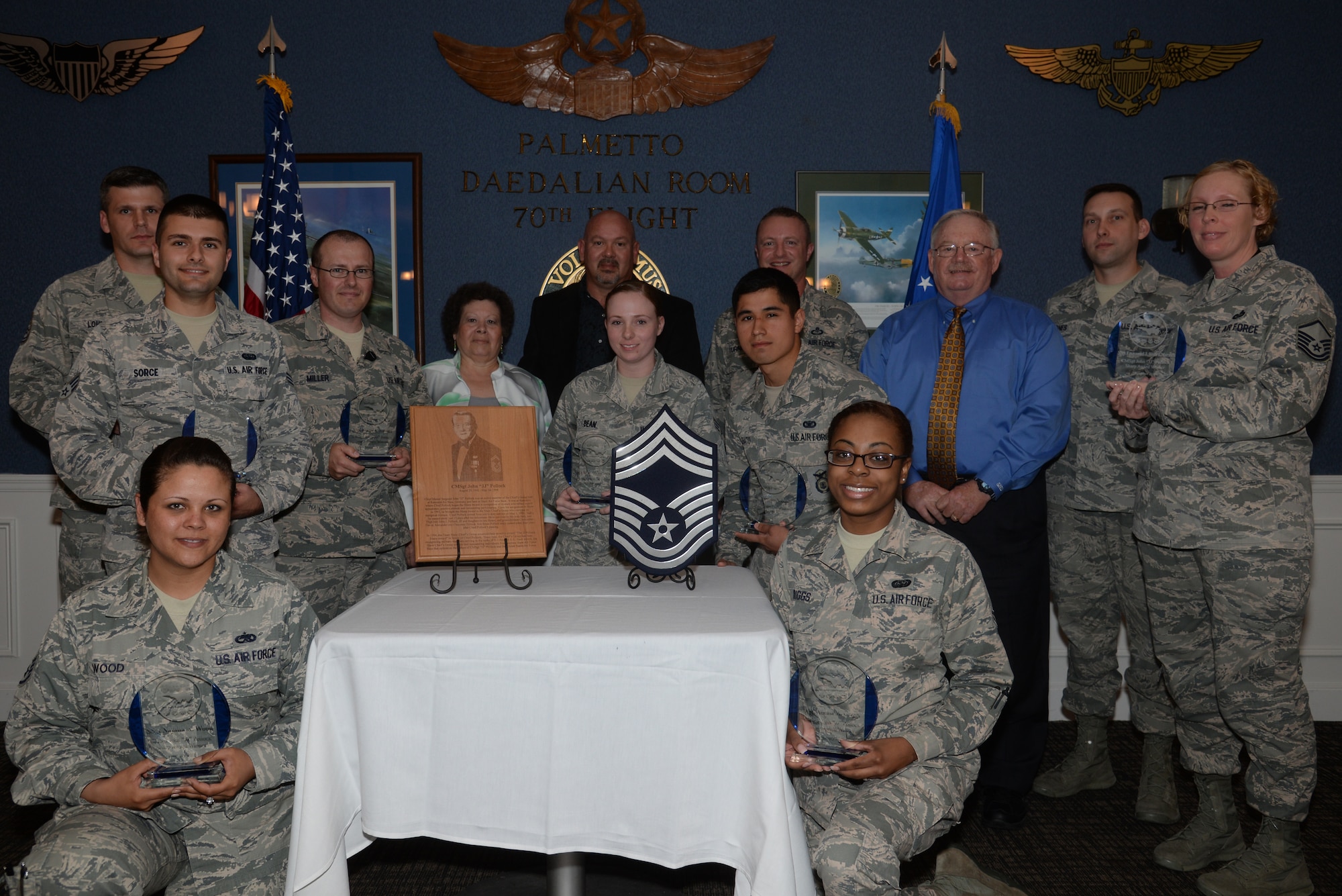 Recipients of the J.J. Pollock award gather for a photo with Judy Pollock and John Pollock III, the wife and son of Chief Master Sgt. J.J. Pollock, along with Steve Dillard, the sponsor of the award, at Shaw Air Force Base, S.C., April 28, 2015. The Team Shaw Chief’s Group awards two Airmen each month for outstanding performance, superior attitude, and impeccable dress and appearance. (U.S. Air Force photo by Senior Airman Jonathan Bass/Released)