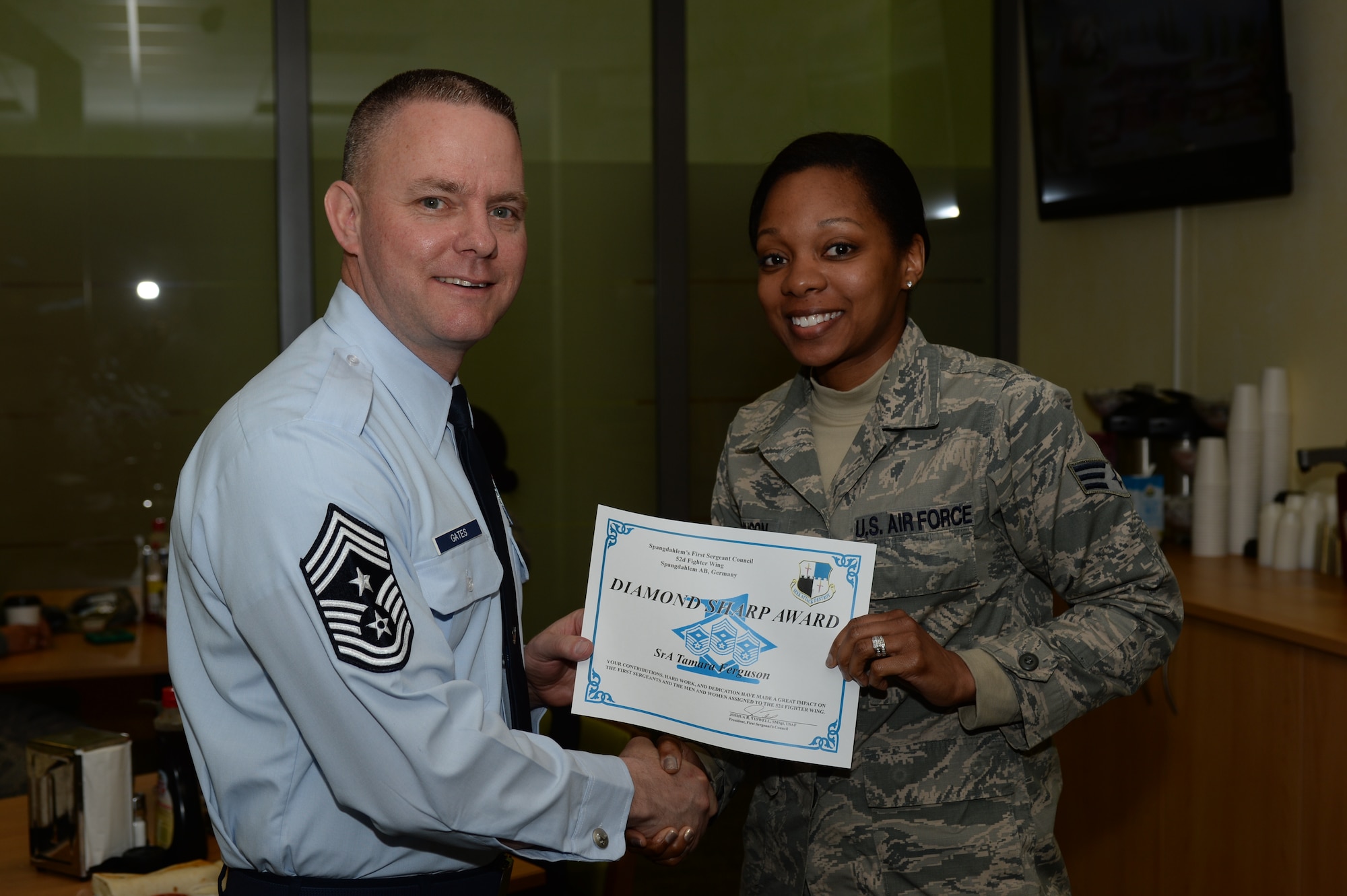 U.S. Air Force Chief Master Sgt. Brian Gates, 52nd Fighter Wing command chief, left, congratulates Senior Airman Tamara Ferguson, 52nd Logistics Readiness Squadron Diamond Sharp Award recipient, during a recognition ceremony at the Eifel Mountain Golf Course at Spangdahlem Air Base, Germany, April 30, 2015. The First Sergeants Council sponsored the program which recognizes Airmen for excellence and professionalism. (U.S. Air Force photo by Staff Sgt. Joe W. McFadden/Released)