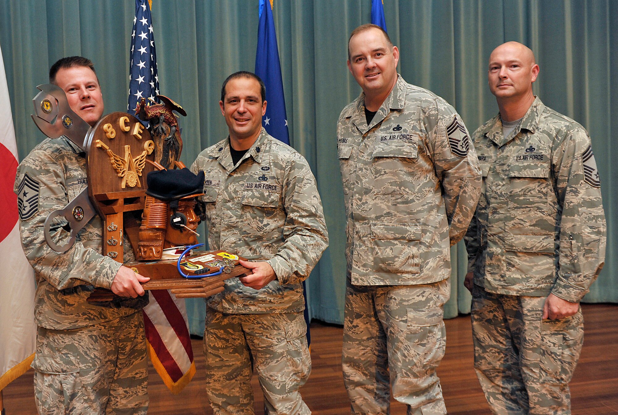 U.S. Air Force Chief Master Sgt. Charles Hoffman, 18th Wing command chief, presents the spirit award to Lt. Col. Peter Gryzen, 18th Maintenance Group deputy commander, during Team Kadena's first quarter awards ceremony at the Keystone Theater on Kadena Air Base, Japan, May 1, 2015. This award is given to the Team Kadena unit who showed "spirit" in their unit through chant and cheers during the ceremony. (U.S. Air Force photo by Naoto Anazawa)