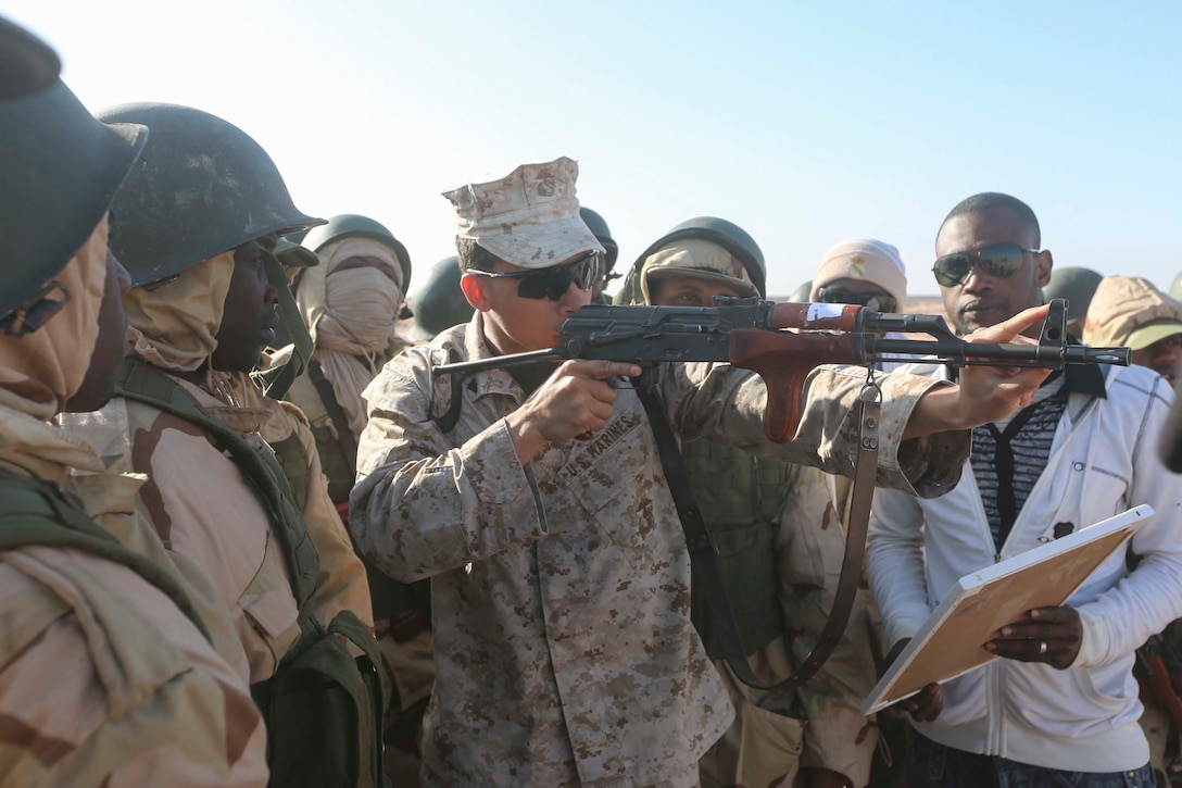 Marine Cpl. Austin Pack, a team leader with Special-Purpose Marine Air-Ground Task Force Crisis Response-Africa, demonstrates aiming in the standing position to Mauritanian Fusilier Marins in Nouadhibou, Mauritania, Feb. 25, 2015. Approximately 20 U.S. Marines, Sailors and Coast Guardsmen with SPMAGTF-CR-AF trained with the Mauritanians, practicing infantry skills such as small boat operations, combat marksmanship and tactical combat casualty care. (Courtesy photo)