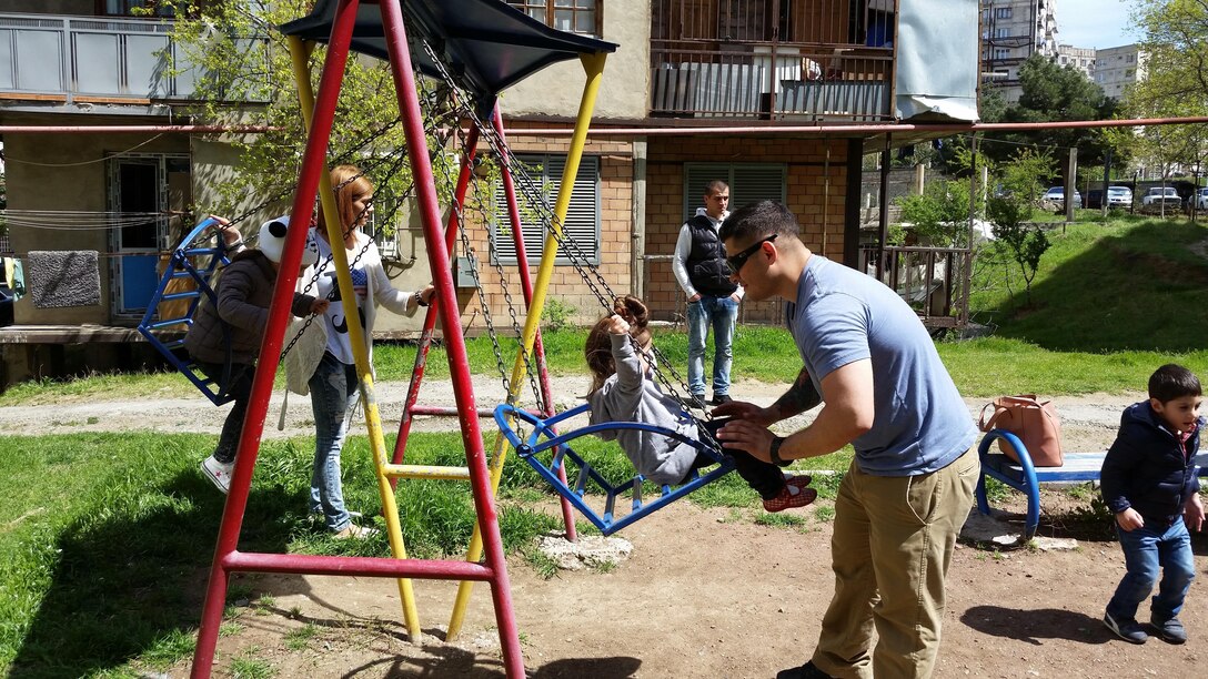 Corporal Jason A. Rigsby, an armorer with the GDP-RSM, pushes Anastasia on the swing set at the neighborhood playground. Marines of Georgia Deployment Program-Resolute Support Mission volunteered their time at KERA’s Women Shelter to help improve and maintain robust relationships with their local community while abroad.