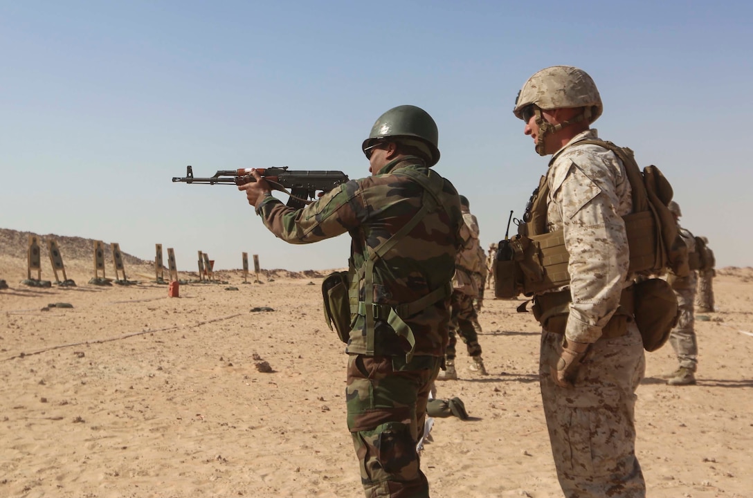 A Mauritanian Fusilier Marin shoots in the standing position as a U.S. Marine observes in Nouadhibou, Mauritania, Feb. 26, 2015. Approximately 20 U.S. Marines, Sailors and Coast Guardsmen with Special-Purpose Marine Air-Ground Task Force Crisis Response-Africa trained with the Mauritanians, practicing infantry skills, combat marksmanship, small boat operations, and tactical combat casualty care. (Courtesy photo)