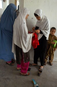 Teenage girls compare photos taken with an instant camera at the women's shura in Asadabad Afghanistan, Oct. 20, 2010. About 50 local women joined Army, Navy and Air Force females from Task Force No Slack for the event, which allowed Afghan females to identify issues and discuss solutions directly with members from the Kunar Provincial Reconstruction Team, the Iowa National Guard's 734th Agribusiness Development Team, and representatives from the local battle space owner.