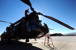 Canadian Air Force Capt. Cameron Fisher, next to rotors, and U.S. Army Sgt. Tommy Rogers, from B Company, 1st Battalion, 189th Aviation Regiment, perform pre-flight checks on a CH-47 Chinook helicopter prior to flying a mission to recover wreckage from a downed U.S. Navy F/A-18 Super Hornet at Fallon Naval Air Station, Nev., Oct. 20, 2010. Soldiers from the 189th trained with the Canadian CH-47 crews to prepare them for an upcoming deployment to Afghanistan.