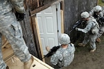 A team of gifted soldier musicians from the 36th Infantry Division Band prepare to clear make shift rooms housing both civilian and hostile targets during an all day training event held on Joint Base Lewis-McChord Oct. 9, 2010 . This training event and many others are designed to assist the 36th ID in their mobilization and deployment to Iraq later this year.