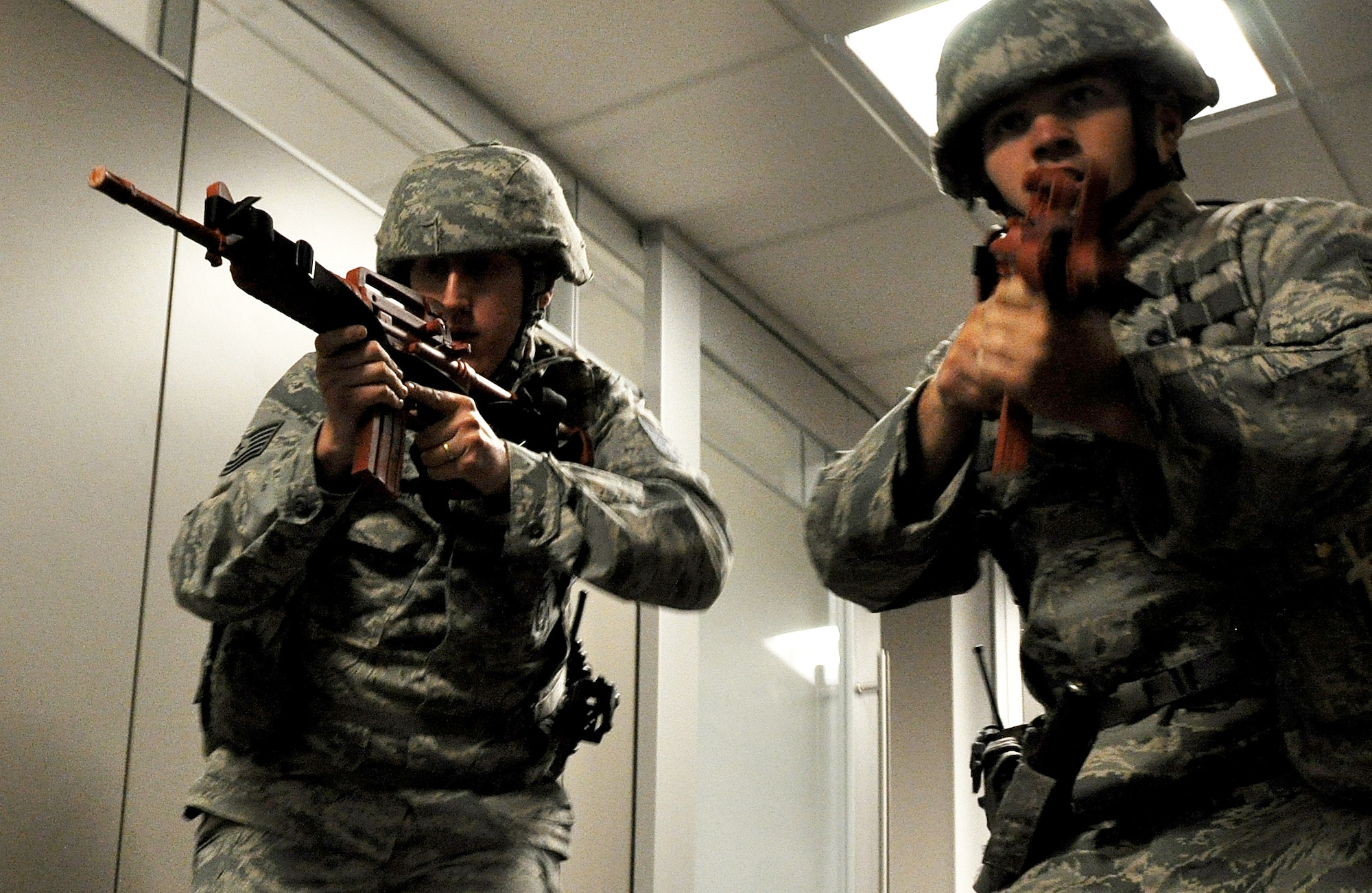 Tech. Sgt. Richard Potter and Staff Sgt. Adam Pollow, 94th Security Forces Squadron members, rush through the hall of the 94th Aeromedical Staging Squadron to find the active shooter in a training exercise April 23, 2015, at Dobbins Air Reserve Base, Ga. The 94th SFS provides active shooter training throughout the year and for individual units and organizations on the base to be better prepared for a real-world incident. (U.S. Air Force photo/Senior Airman Daniel Phelps)