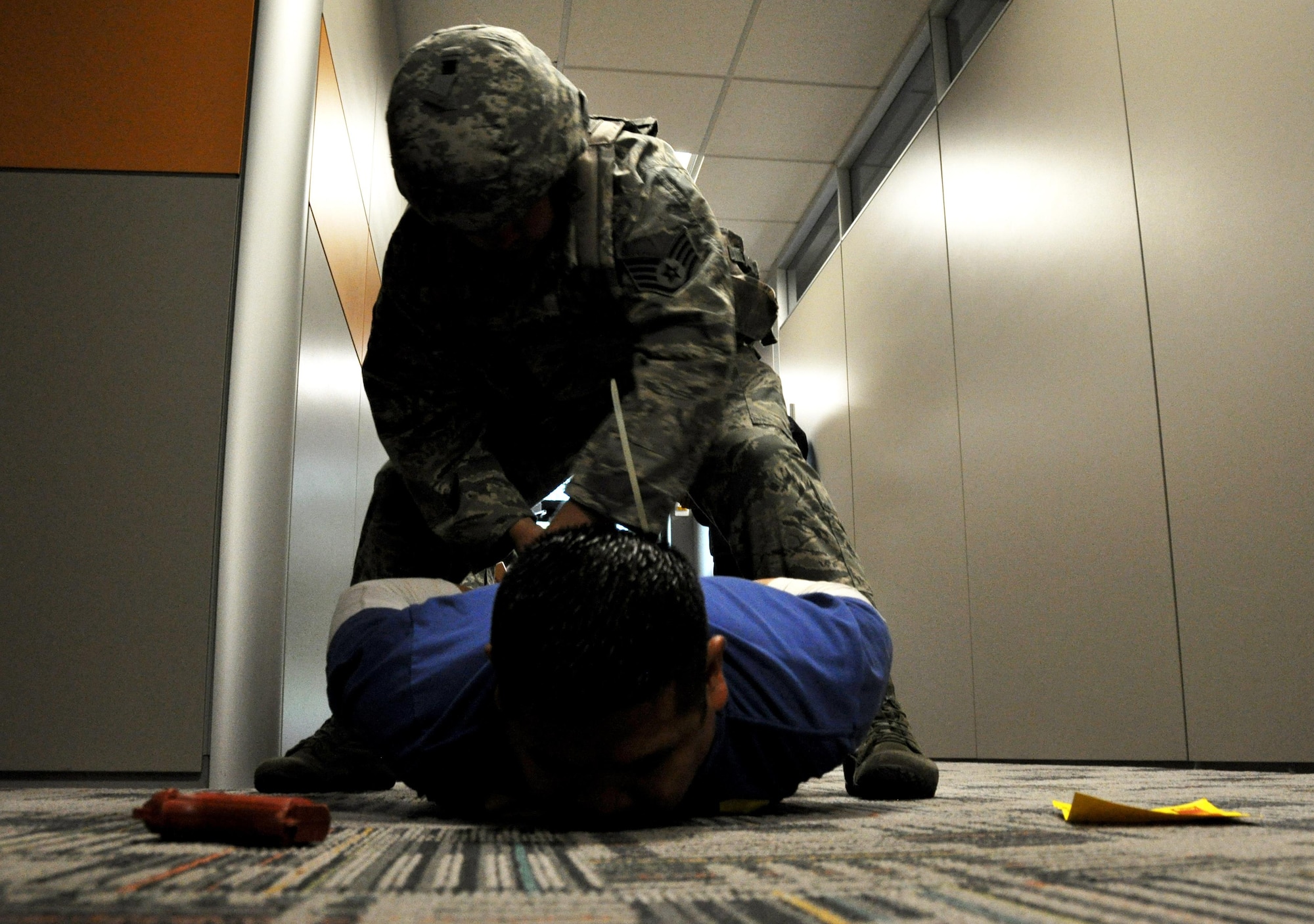 Staff Sgt. Adam Pollow, 94th Security Forces Squadron member, takes down Tech. Sgt. Michael Sapanza, 94th SFS member who was portraying the active shooter, during a training exercise in the 94th Aeromedical Staging Squadron April 23, 2015, at Dobbins Air Reserve Base, Ga. The 94th SFS provides active shooter training throughout the year and for individual units and organizations on the base to be better prepared for a real-world incident. (U.S. Air Force photo/Senior Airman Daniel Phelps)
