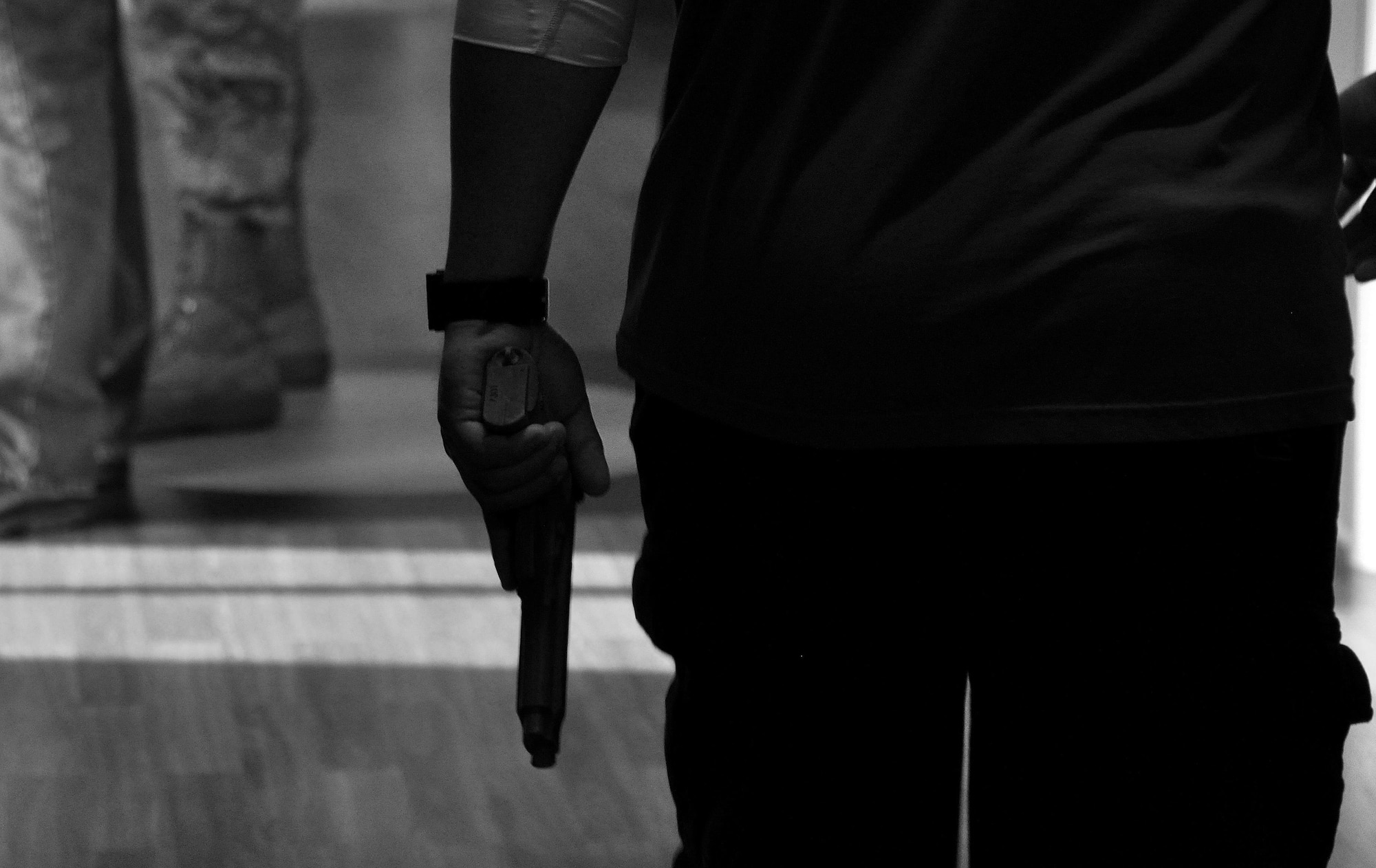Tech. Sgt. Michael Sapanza, 94th Security Forces Squadron, strolls down the hall of the 94th Aeromedical Staging Squadron with a dummy M-9 playing the role of an active shooter during a training exercise April 23, 2015, at Dobbins Air Reserve Base, Ga. This active shooter exercise included all tenant units at Dobbins ARB and the Cobb County Police Department working together to respond to an emergency situation. (U.S. Air Force photo/Senior Airman Daniel Phelps)