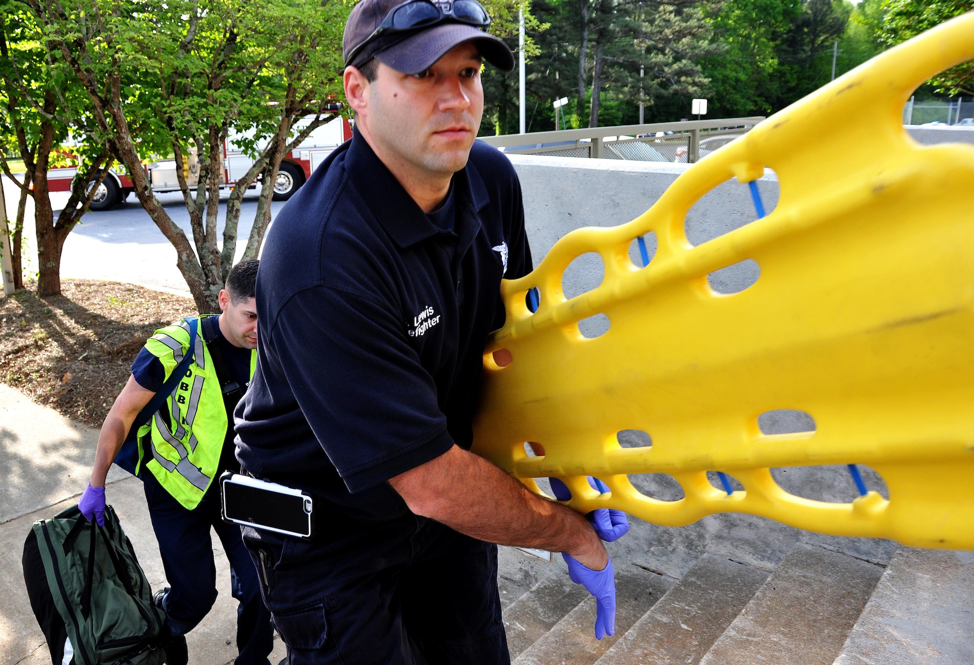 Scott Lewis and David Christensen, Dobbins Firefighters, rush up to the steps towards the 94th Aeromedical Staging Squadron to treat any “victims” during an active shooter training exercise April 23, 2015, at Dobbins Air Reserve Base, Ga. The point of this exercise was to test the interoperability of Dobbins and Cobb County and to ensure mission partners were aware of what their role in a scenario like this would be. (U.S. Air Force photo/Senior Airman Daniel Phelps)