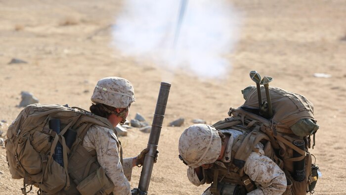 Cpl. Jacklyn Dean, left, and Sgt. Rebecca Rutherford, right, both mortar men with Ground Combat Element Integrated Task Force, fire an M224 60mm light-weight mortar during a Marine Corps Operational Test and Evaluation Activity assessment at Range 107, Marine Corps Air Ground Combat Center Twentynine Palms, California, April 23, 2015. From October 2014 to July 2015, the GCEITF will conduct individual and collective level skills training in designated ground combat arms occupational specialties in order to facilitate the standards-based assessment of the physical performance of Marines in a simulated operating environment performing specific ground combat arms tasks. 