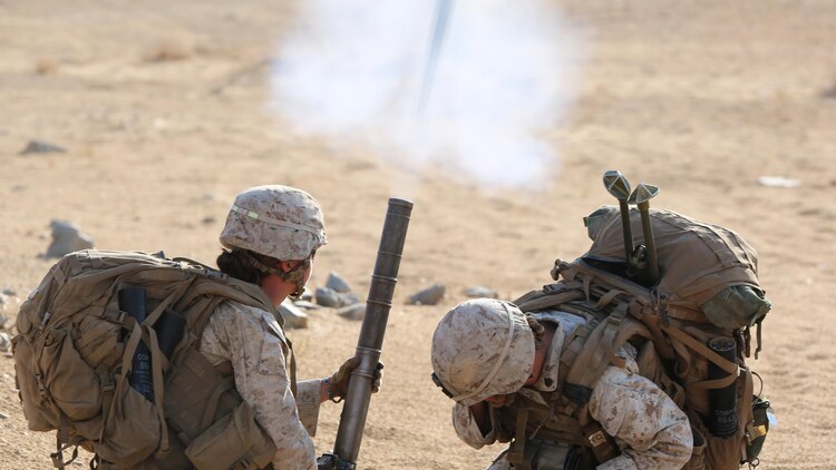 Cpl. Jacklyn Dean, left, and Sgt. Rebecca Rutherford, right, both mortar men with Ground Combat Element Integrated Task Force, fire an M224 60mm light-weight mortar during a Marine Corps Operational Test and Evaluation Activity assessment at Range 107, Marine Corps Air Ground Combat Center Twentynine Palms, California, April 23, 2015. From October 2014 to July 2015, the GCEITF will conduct individual and collective level skills training in designated ground combat arms occupational specialties in order to facilitate the standards-based assessment of the physical performance of Marines in a simulated operating environment performing specific ground combat arms tasks. 