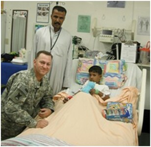 Capt. James Collins, chaplain with the 2nd Squadron, 108th Cavalry Regiment, 224th Sustainment Brigade, 103rd Sustainment Command (Expeditionary), visits Akram and his father at the 28th Combat Support Hospital at Contingency Operating Base Adder, Iraq Oct. 1, 2010.