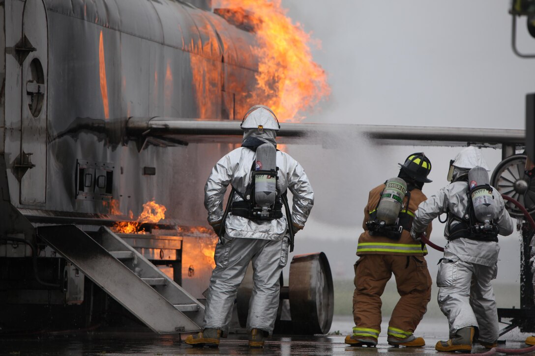 Marines with Aircraft Rescue and Firefighting partnered with Wilmington Fire Department members to put out flames coming from a Mobile Aircraft Firefighting Training Device during training at Marine Corps Air Station Cherry Point, North Carolina, April 30, 2015. Numerous firefighting exercises were conducted during the training session. The Marines are aircraft rescue firefighters with Headquarters and Headquarters Squadron here.