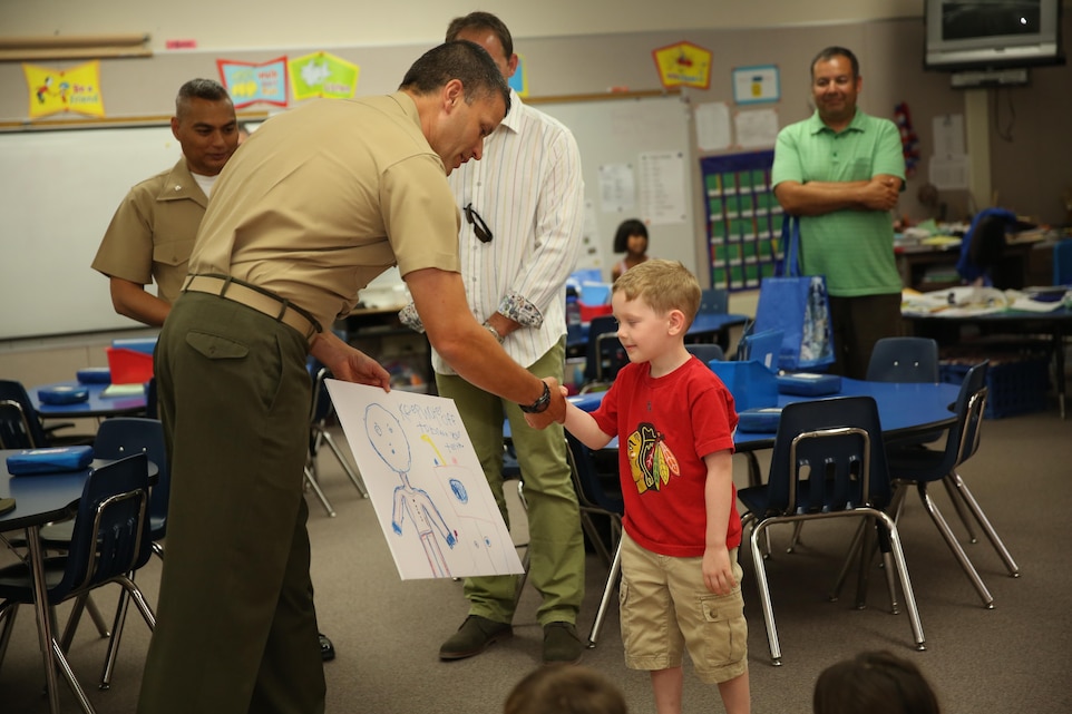 Lt. Col. Timothy Pochop, director, Natural Resources and Environmental Affairs, shakes the hand of Mitchell Klich, Earth Day poster finalist, Condor Elementary, while recognizing him for being a finalist during the Earth Day Poster Contest May 1, 2015. The nine finalists were categorized by grade: kindergarten through second grade, third through fourth, and fifth through sixth. (Official Marine Corps photo by Lance Cpl. Thomas Mudd/Released)