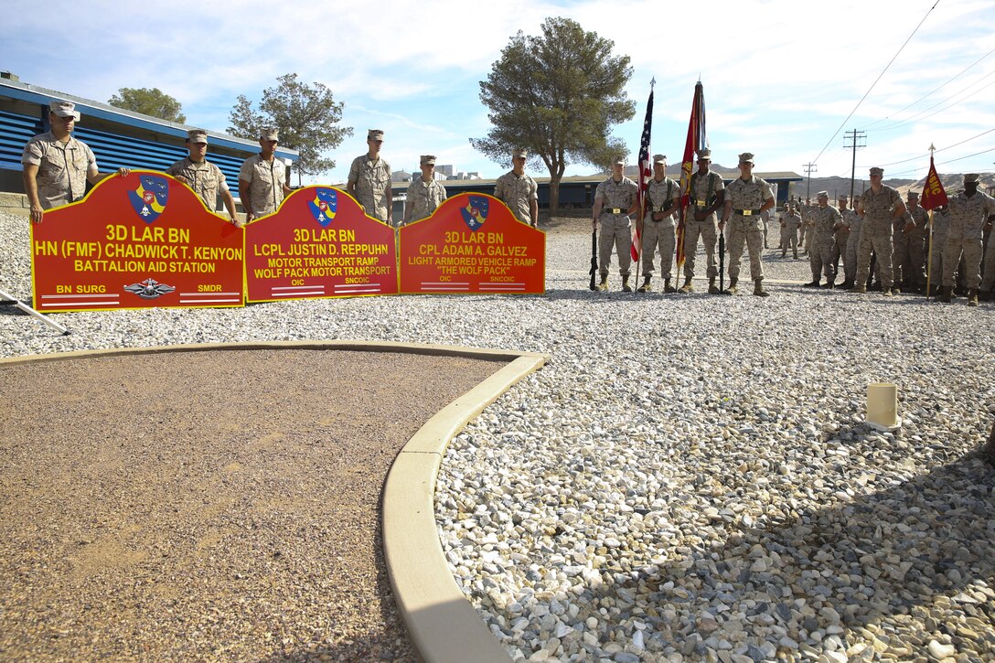 Marines with 3rd Light Armored Reconnaissance Battalion hold signs with the new names of three 3rd LAR buildings aboard the Combat Center during a building dedication ceremony at 3rd LAR Headquarters Building, April 30, 2015. (Official Marine Corps photo by Pfc. Levi Schultz/Released)