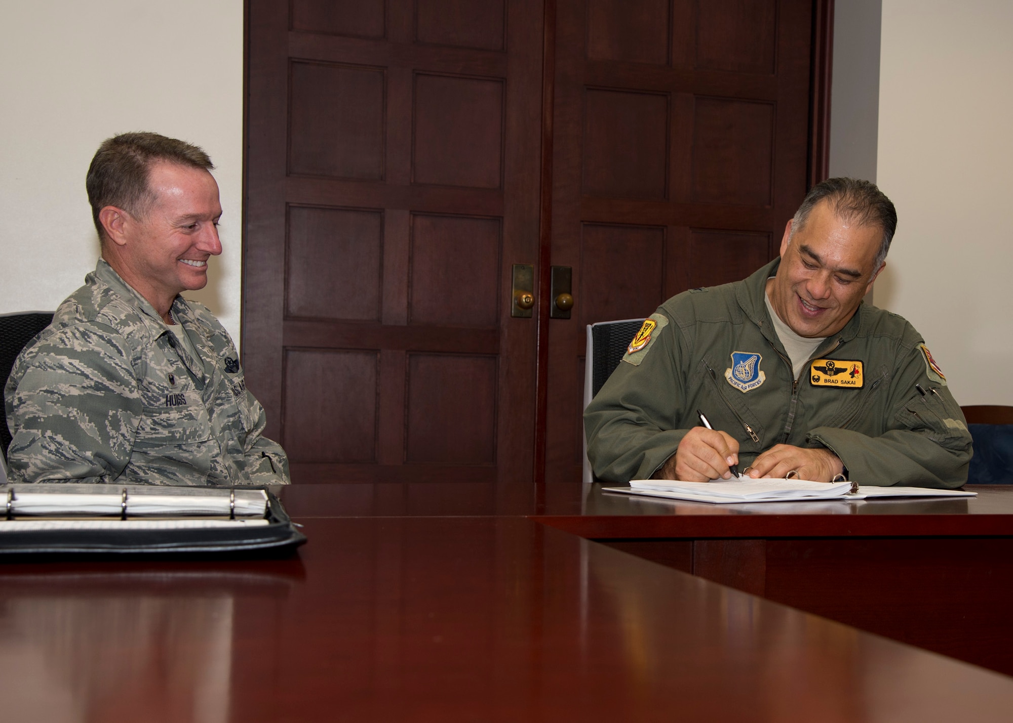 (Right) Brig. Gen. Braden Sakai, 154th Wing commander and  Col. Randall Huiss, 15th Wing commander, sign the 2015 Installation Deployment Plan on Joint Base Pearl Harbor-Hickam, Hawaii, May 1, 2015.The IDP provides a framework for how the 15th Wing, the 154th Wing and JBPHH will work together to deploy Airmen to support combatant commanders down range. The IDP gives instruction on how to deploy a single Airman or squadron of Airmen for a natural disaster or a hostile event. (U.S. Air Force photo by Tech. Sgt. Aaron Oelrich/Released)