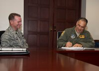 (Right) Brig. Gen. Braden Sakai, 154th Wing commander and  Col. Randall Huiss, 15th Wing commander, sign the 2015 Installation Deployment Plan on Joint Base Pearl Harbor-Hickam, Hawaii, May 1, 2015.The IDP provides a framework for how the 15th Wing, the 154th Wing and JBPHH will work together to deploy Airmen to support combatant commanders down range. The IDP gives instruction on how to deploy a single Airman or squadron of Airmen for a natural disaster or a hostile event. (U.S. Air Force photo by Tech. Sgt. Aaron Oelrich/Released)