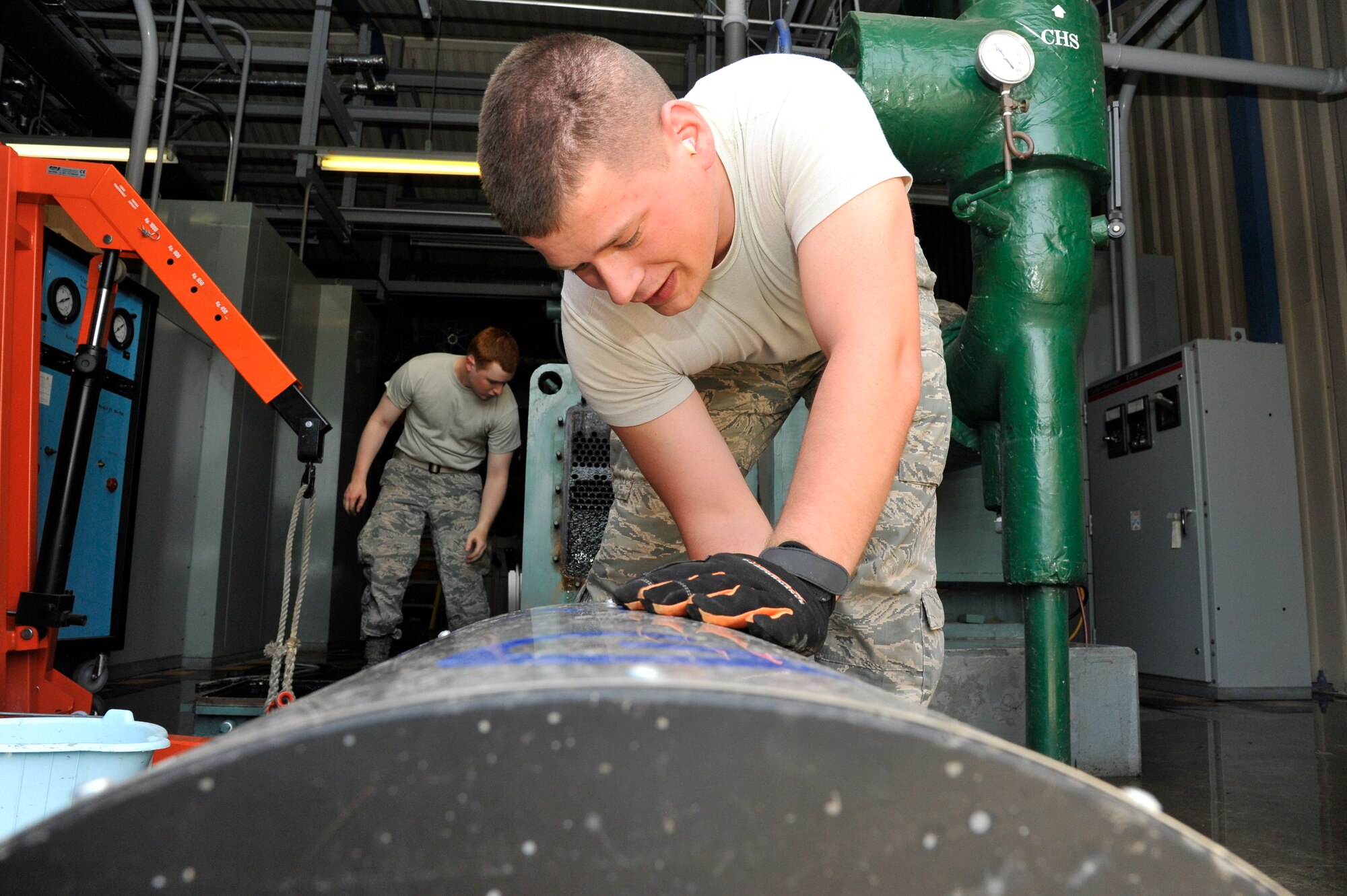 U.S. Air Force Senior Airman Benjamin Mathias, 35th Civil Engineer Squadron Heating Ventilation and Air Conditioning journeyman, turns on a siphoning machine at Misawa Air Base, Japan, May 5, 2015. The machine features a bore and brush that enters numerous coils of a chilling unit, cleaning it out by rapidly spinning. (U.S. Air Force photo by Senior Airman Patrick S. Ciccarone/Released)