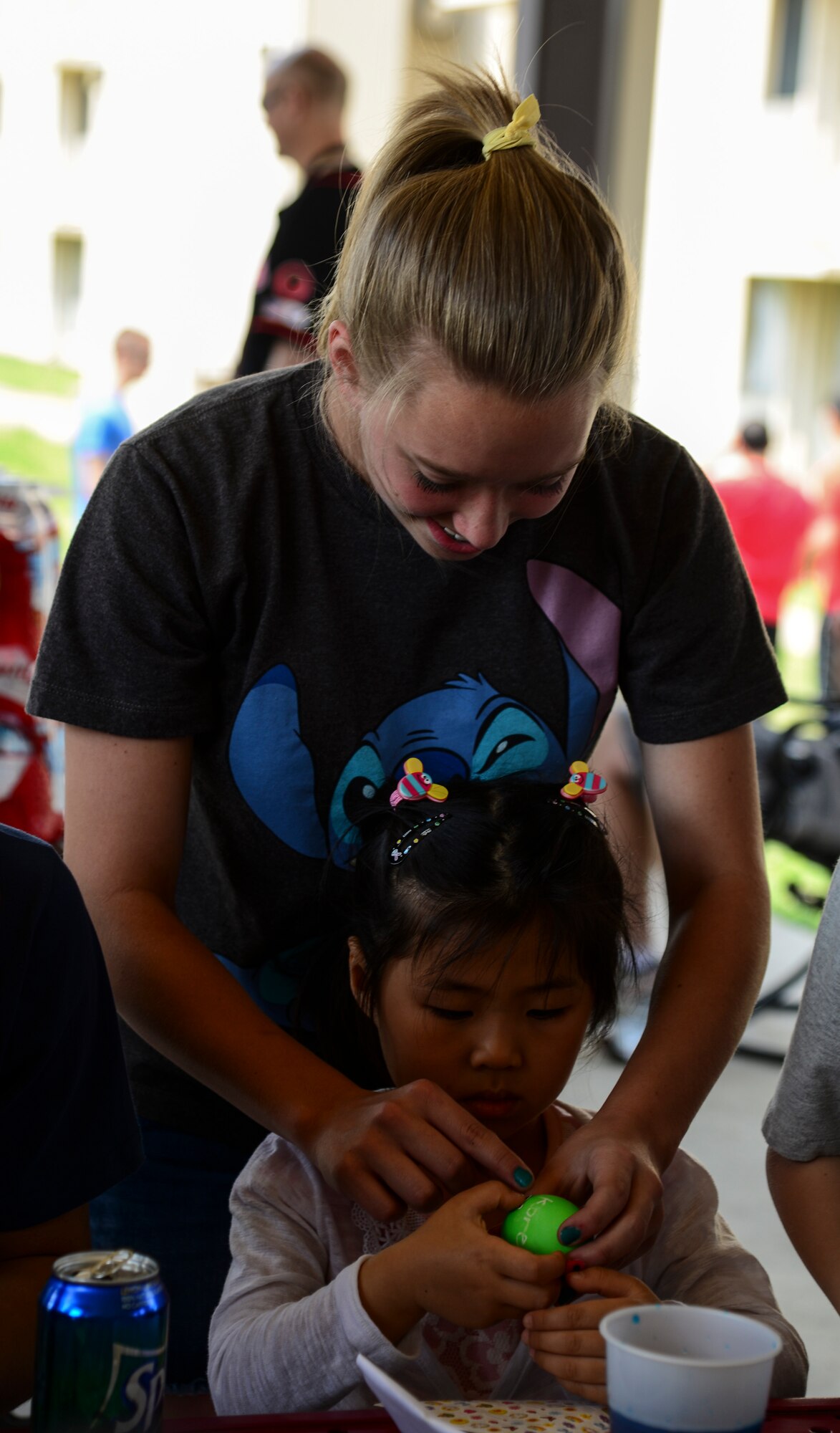 Avery Lokowich, daughter of Lt. Col. Luke Lokowich, 5th  Reconnaissance Squadron commander and a U-2 pilot, helps a young Korean girl from Lira Orphanage put stickers onto a colored egg during a 5th RS sponsored barbecue April 26, 2015, at Osan Air Base, Republic of Korea. The 5th RS visits the orphanage twice a year as well as invite them the base for barbecues. (U.S. Air Force photo by Senior Airman Matthew Lancaster)