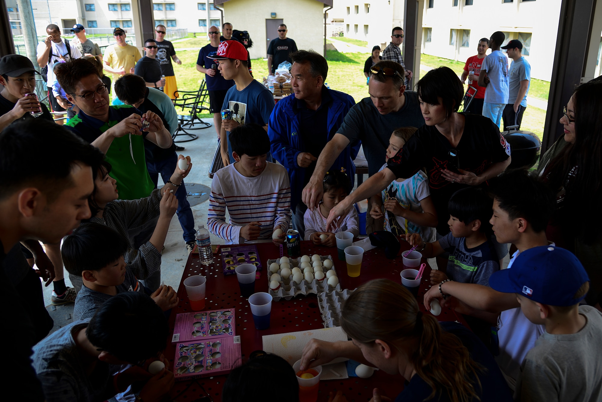 Members of the 5th Reconnaissance Squadron assist Korean children from Lira Orphanage with dying eggs  during a 5th RS sponsored barbecue April 26, 2015, at Osan Air Base, Republic of Korea. The 5th RS had been sponsoring the orphanage for two years. (U.S. Air Force photo by Senior Airman Matthew Lancaster)